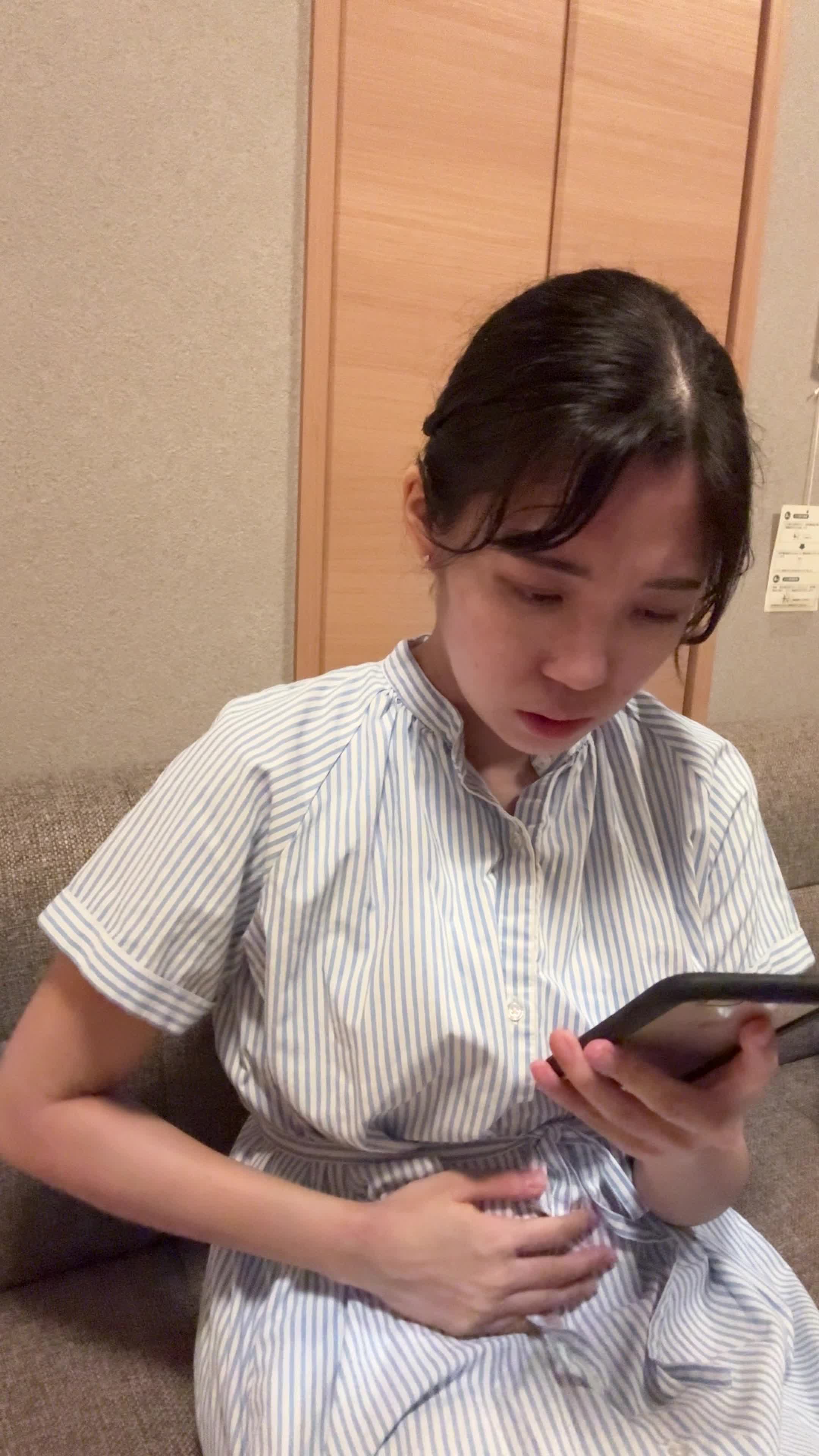 ソファでスマホを見ながら、「腸活の方法を見つけて試したいけど迷う」表情