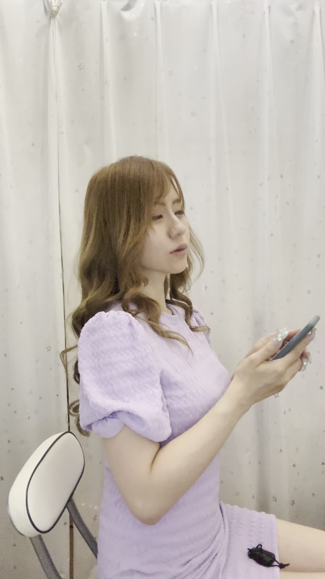 椅子に浅く腰掛け、「クーポンを適用してさらにお得に」とスマホを操作する姿
