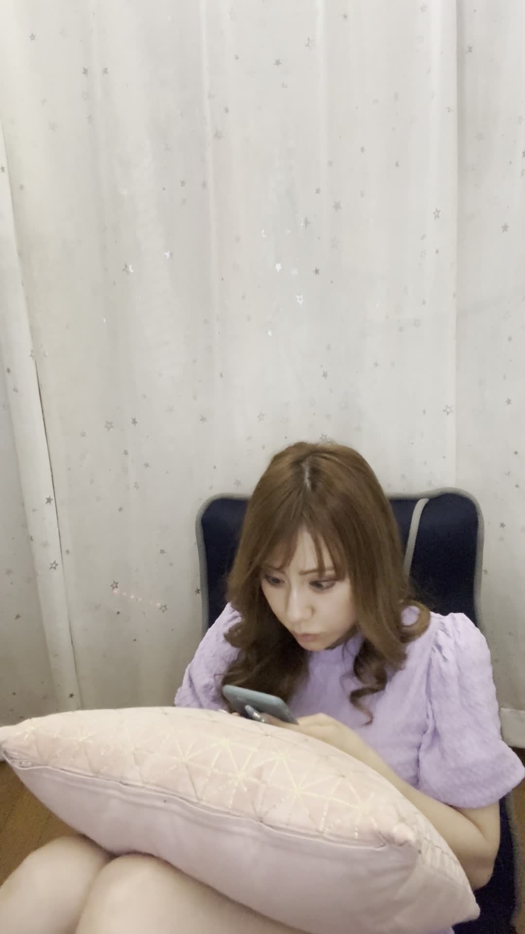 ソファでクッションを抱え、スマホの画面を見て「これがタイムセール価格？」と驚く様子