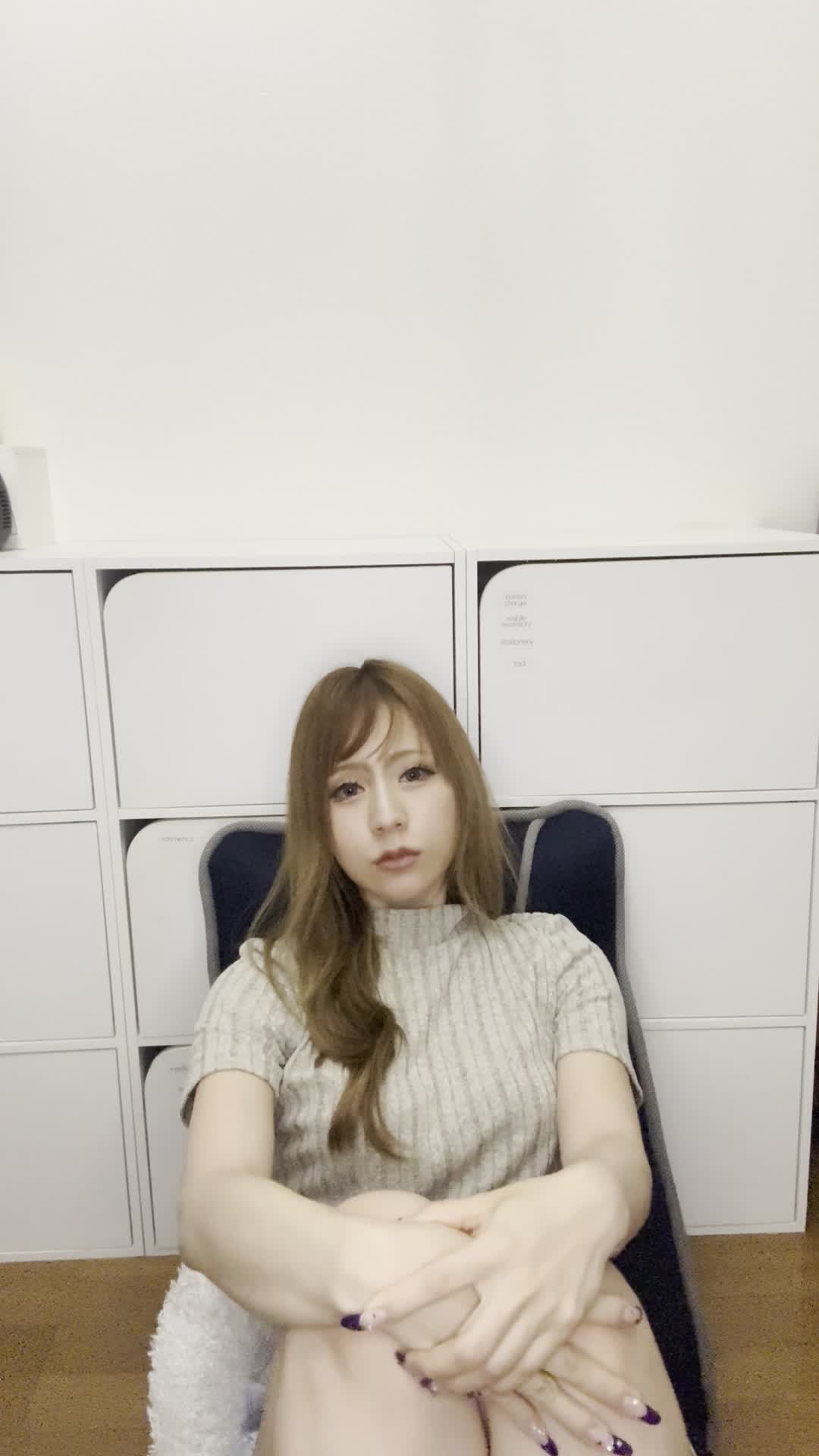ソファで膝を抱え、「白髪が目立つのをどう隠すか考える」少し困った様子
