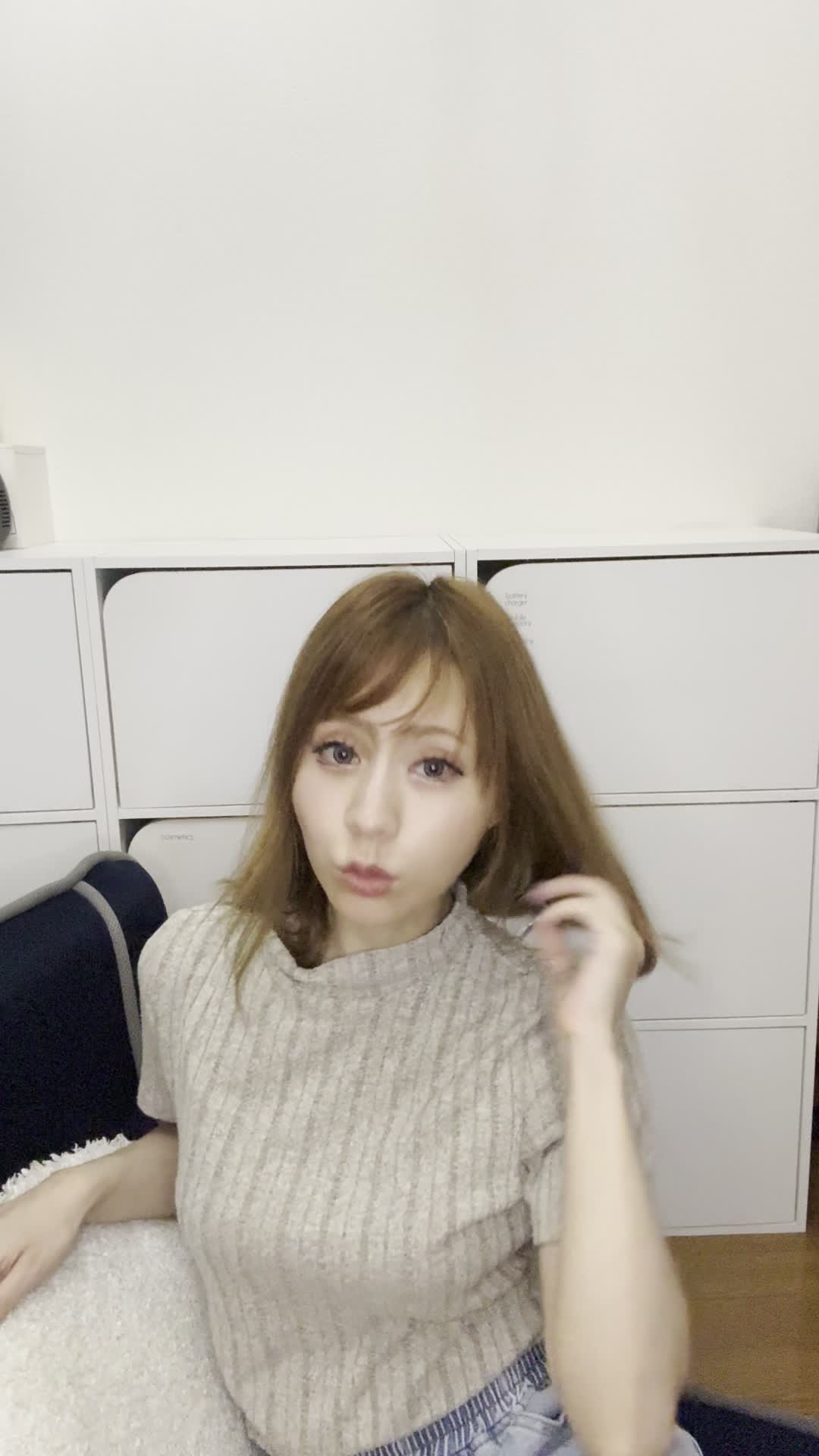 ソファで友達と話しながら、「白髪が気にならないヘアスタイルを聞いている」姿