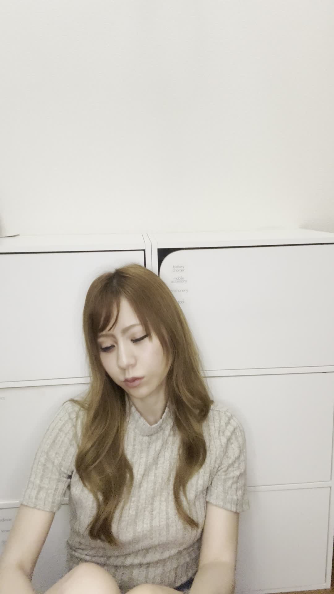 床に座り込み、鏡を近づけて白髪をじっくり確認し、「これがなくなれば…」と考える仕草