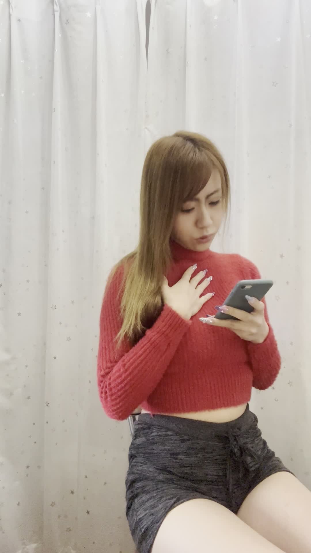 椅子に腰掛け、スマホの画面を見ながら「体臭ケアの口コミを読んで安心する」表情