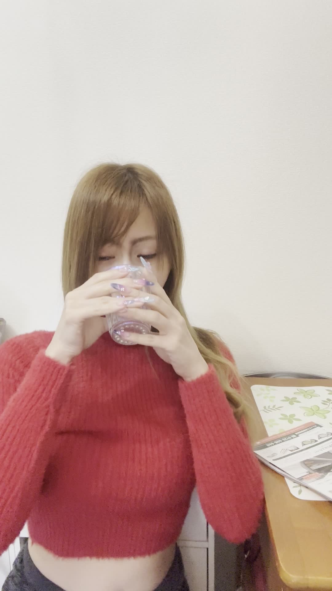 テーブルで水を飲みながら、「次の体臭ケアアイテムを選ぶ」リラックスした表情