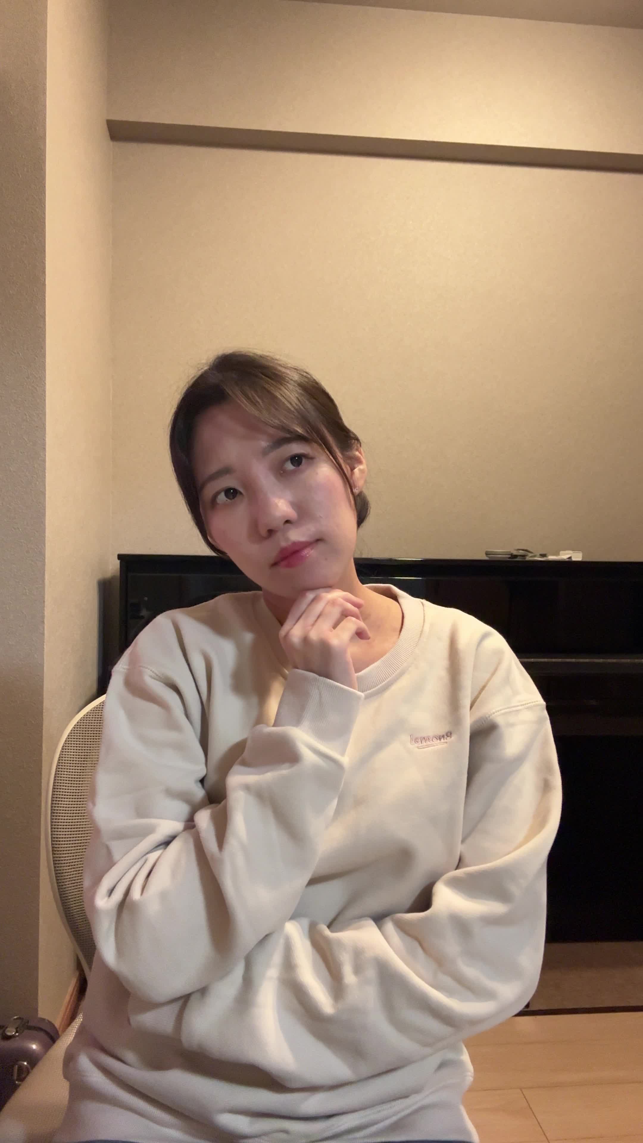 椅子に浅く腰掛け、「飲み物で少しでも元気を取り戻せる？」と悩む様子