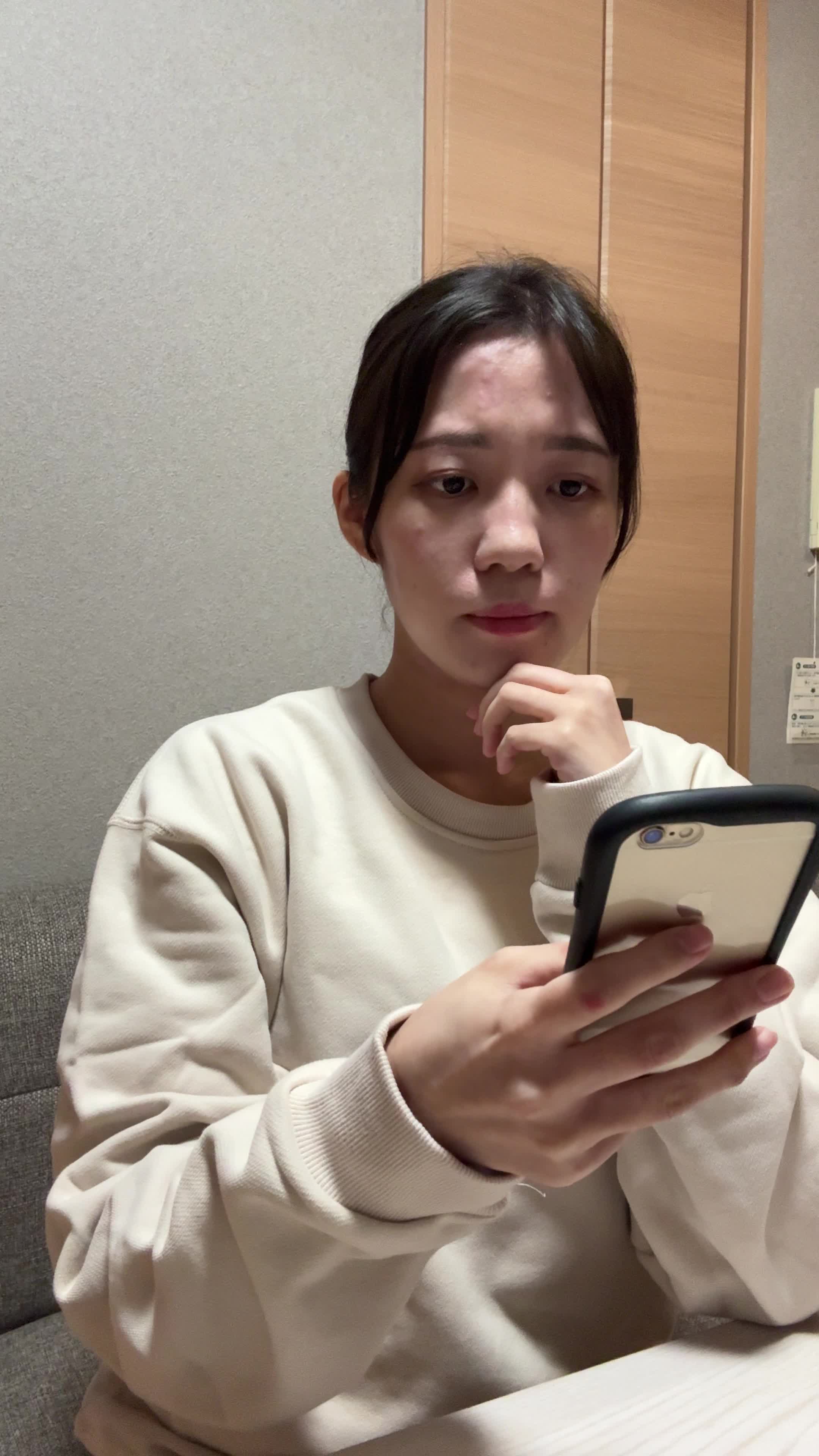 テーブルでスマホを見ながら、「体調を整える方法を必死に検索する」真剣な表情