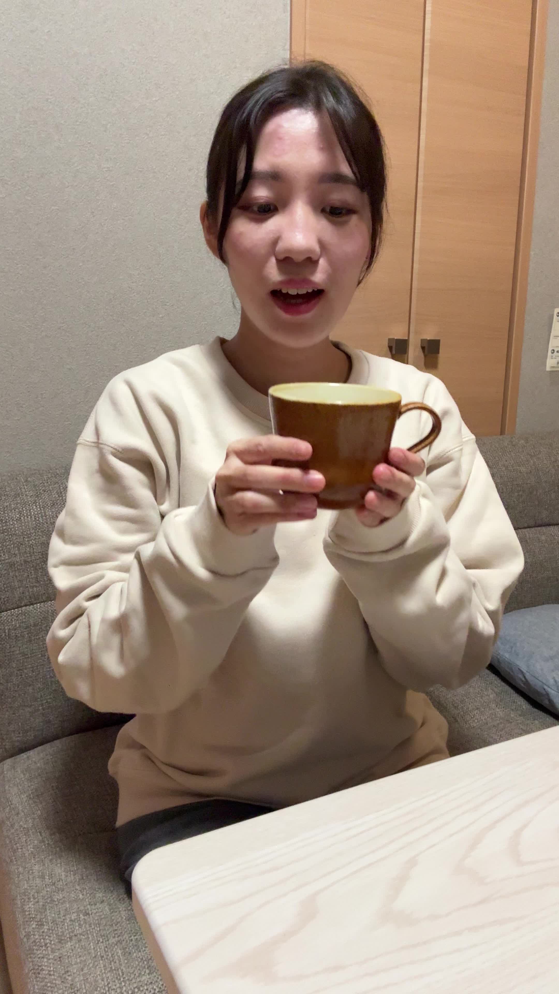 テーブルでカップを手に取り、「少しずつ体が良くなる期待を込めて飲み始める」微笑み