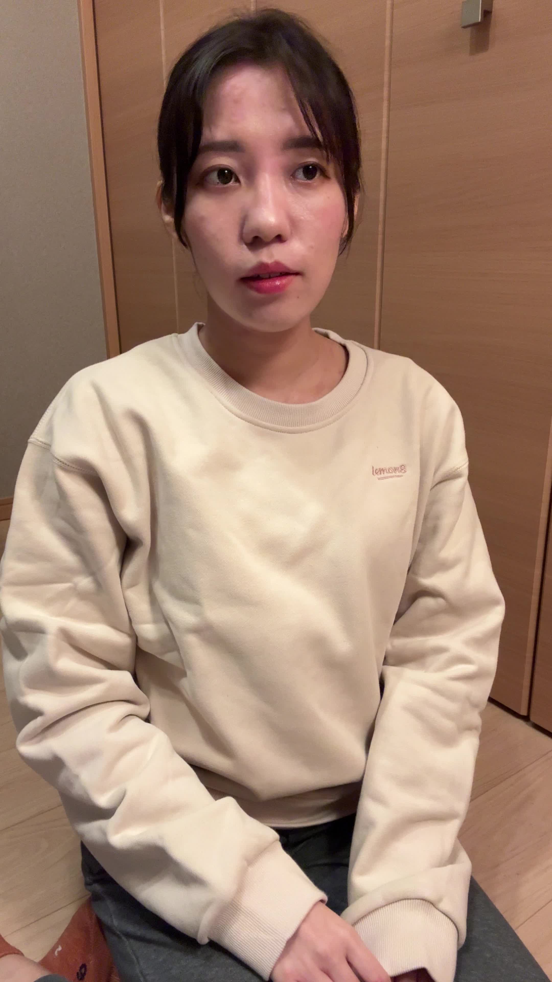 床で両手を膝に置き、「健康ドリンクで元気を取り戻したい」と決意を固める姿