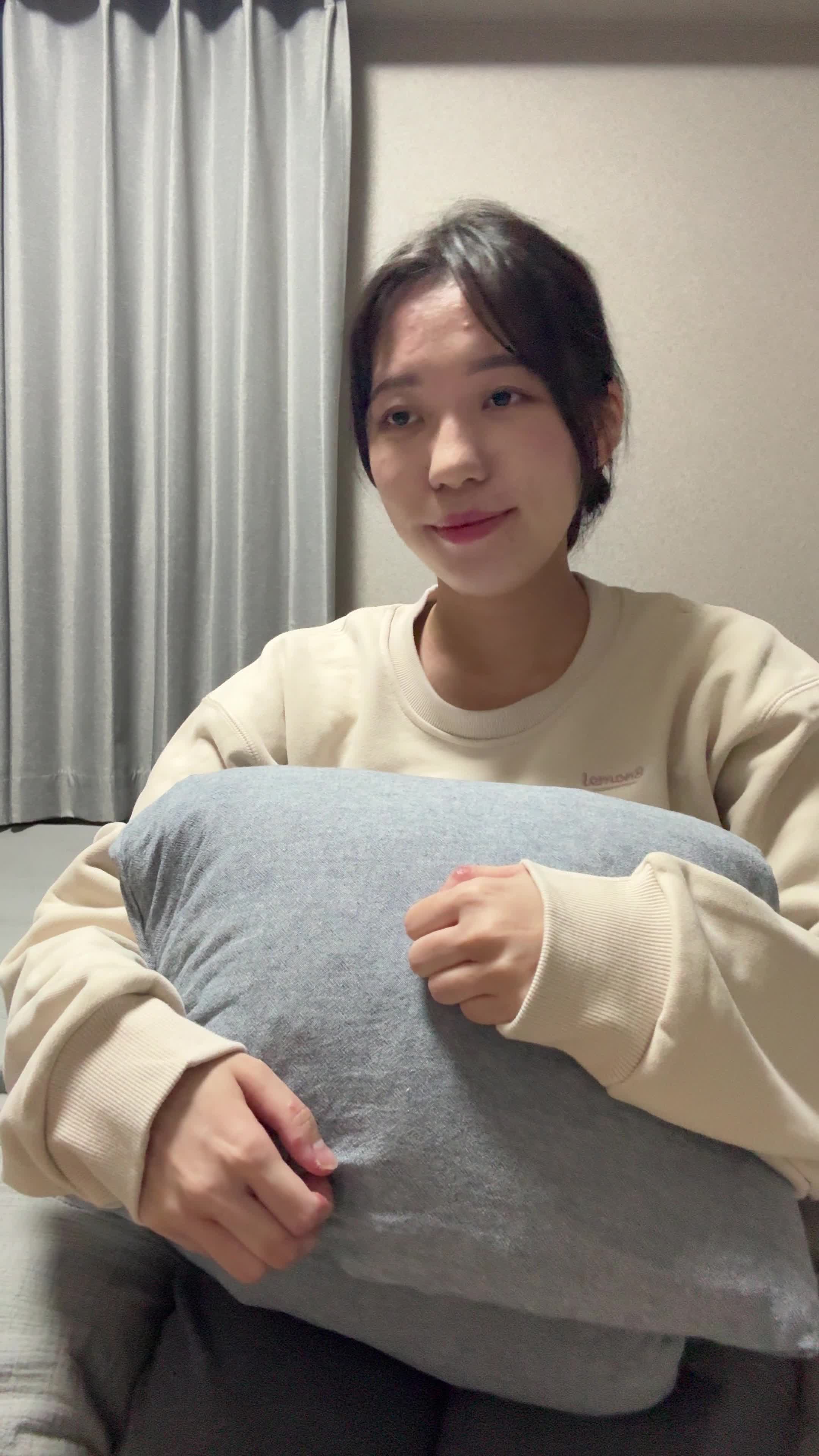 ベッドでクッションを抱え、「このドリンクを続けたら変化があるかな？」と未来を想像する表情