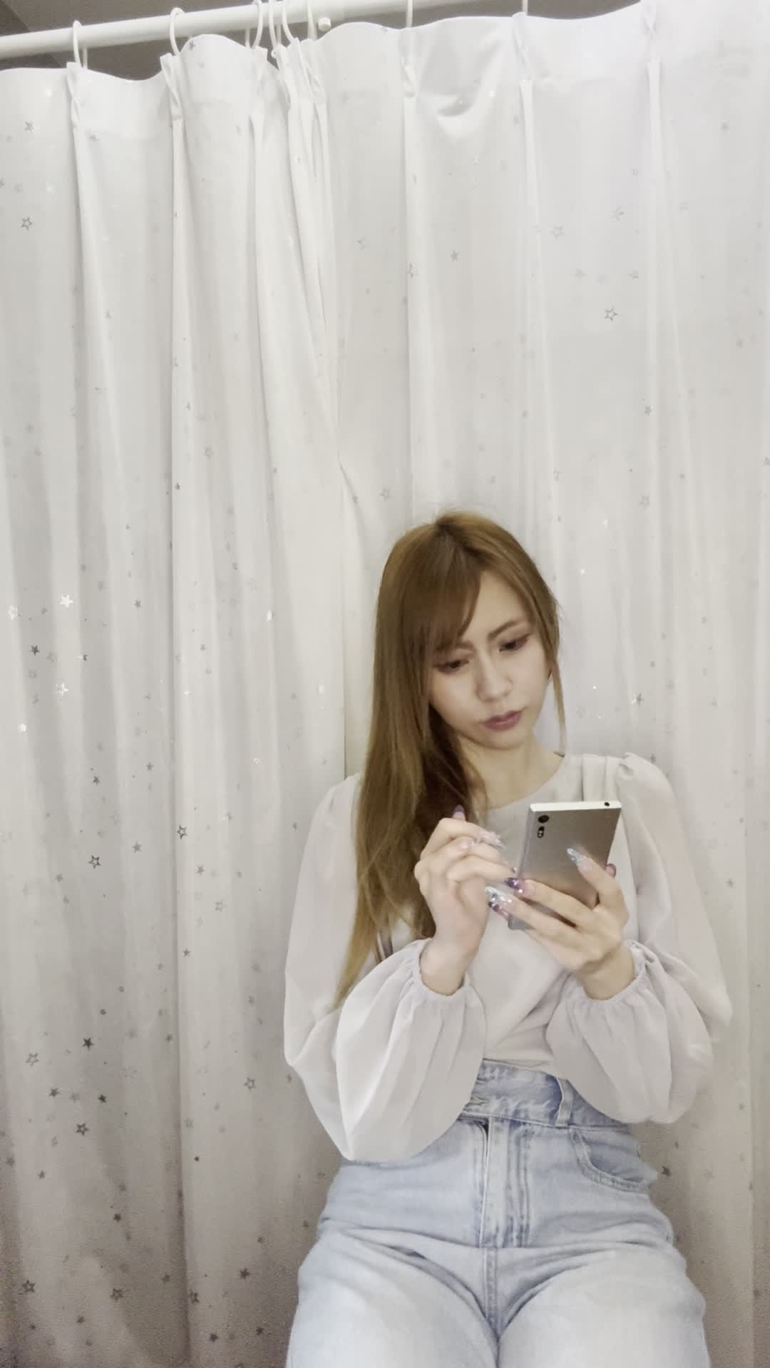 椅子に腰掛け、「スマホの求人アプリを操作して理想の条件を探す」動作