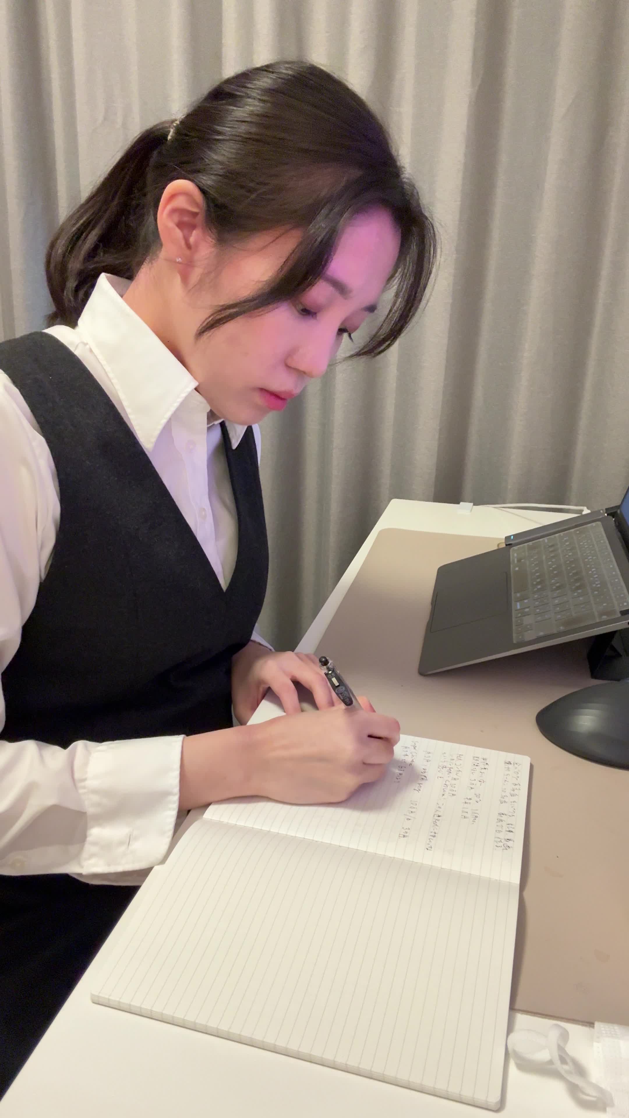 テーブルでノートに書きながら考える真剣な姿