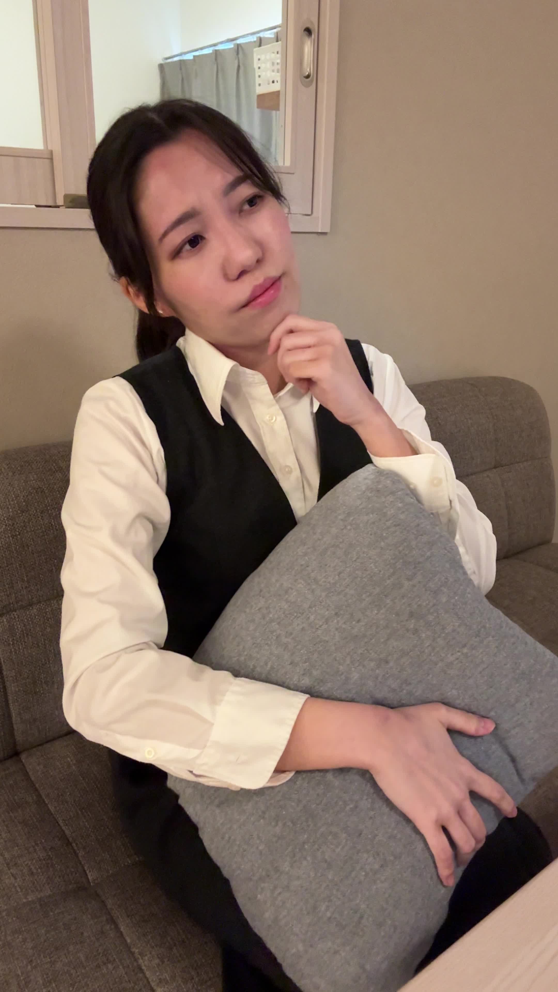 ソファでクッションを抱え、「家族のためにどのプランがいいんだろう」と悩む様子