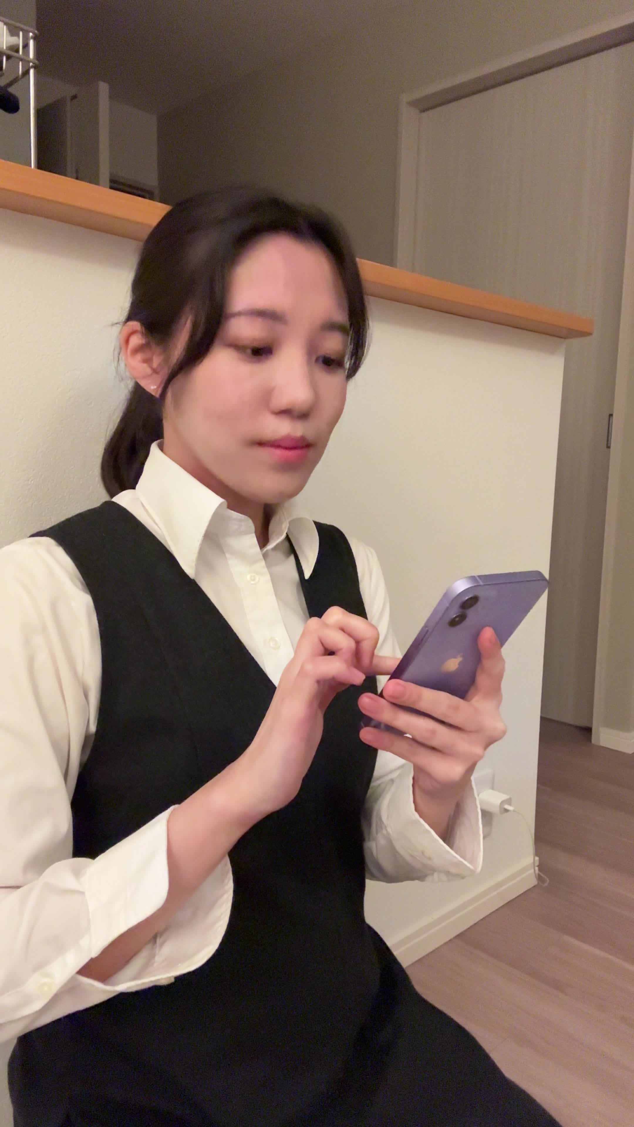 床に座り込み、スマホで「保険の口コミ」を見ながら少し安心した表情を浮かべる