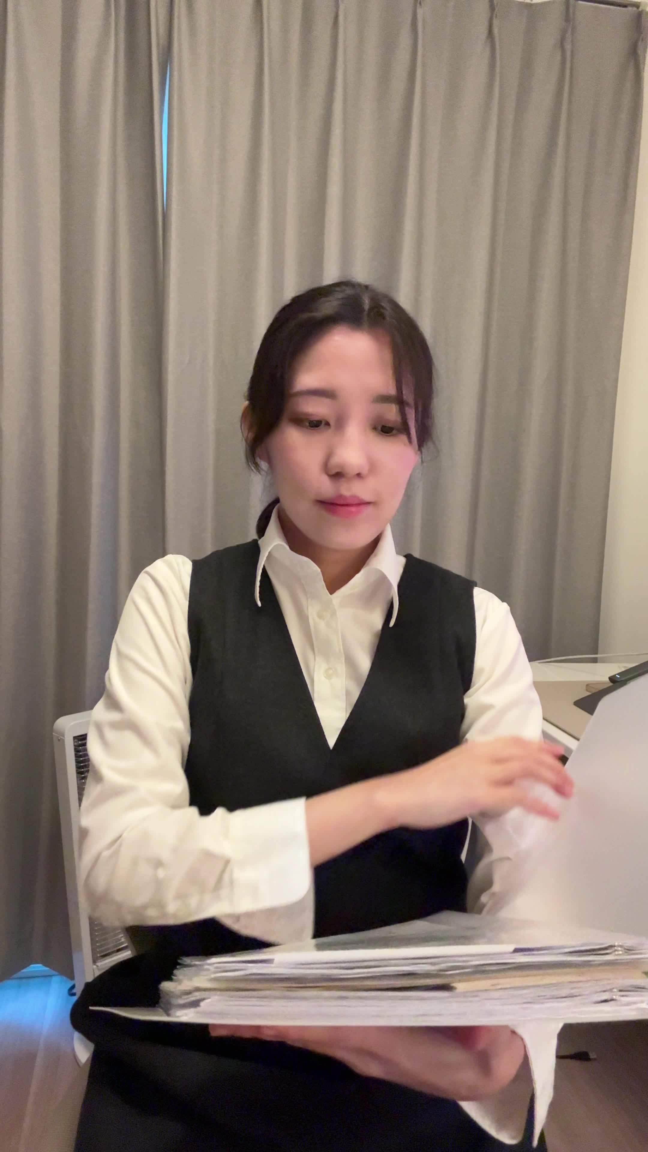 椅子に腰掛け、資料を閉じて「これで次のステップに進もう」と決意を示す表情