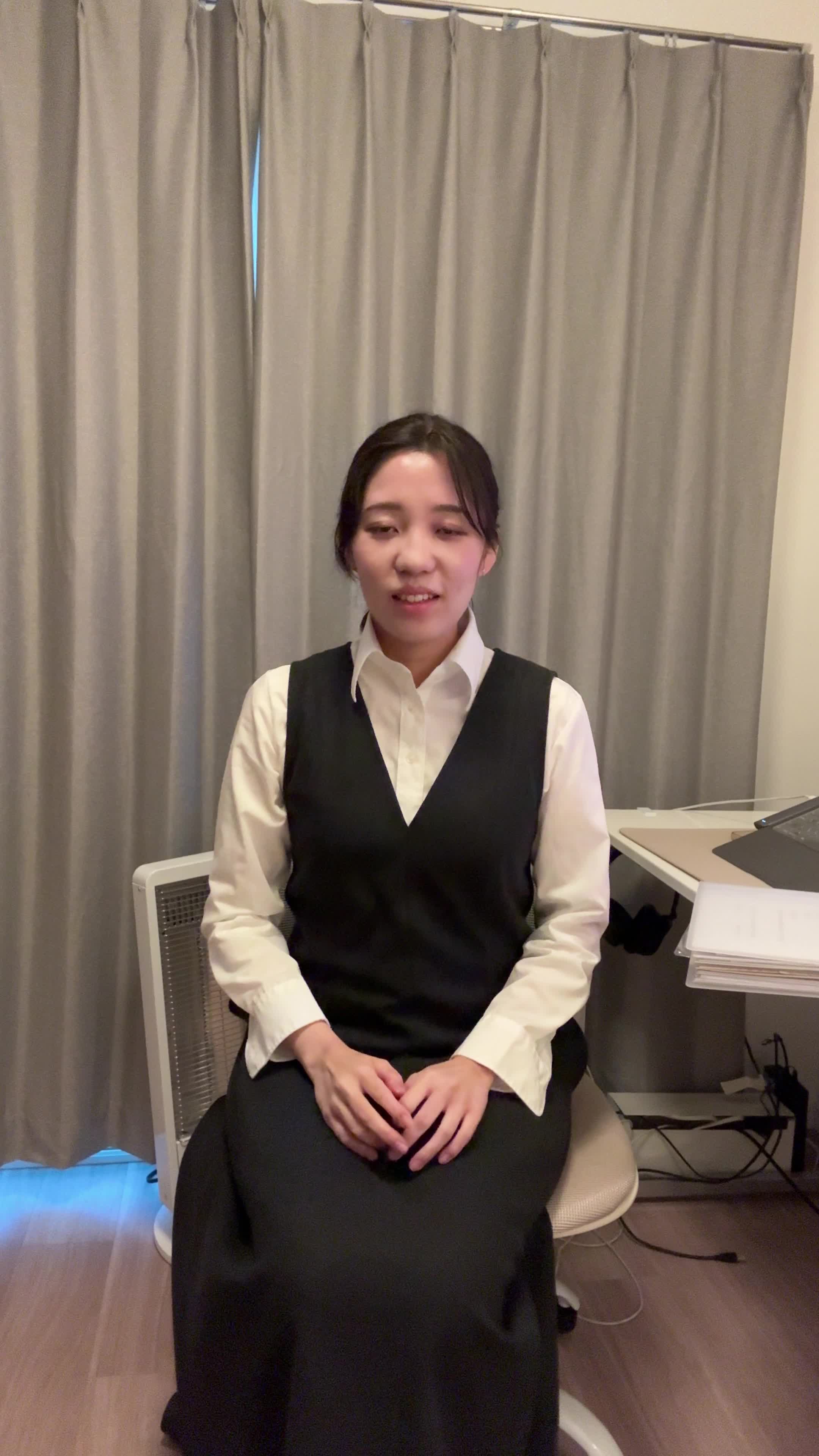 椅子から立ち上がり、「これで備えは万全」と自信を持つ笑顔を見せる動作
