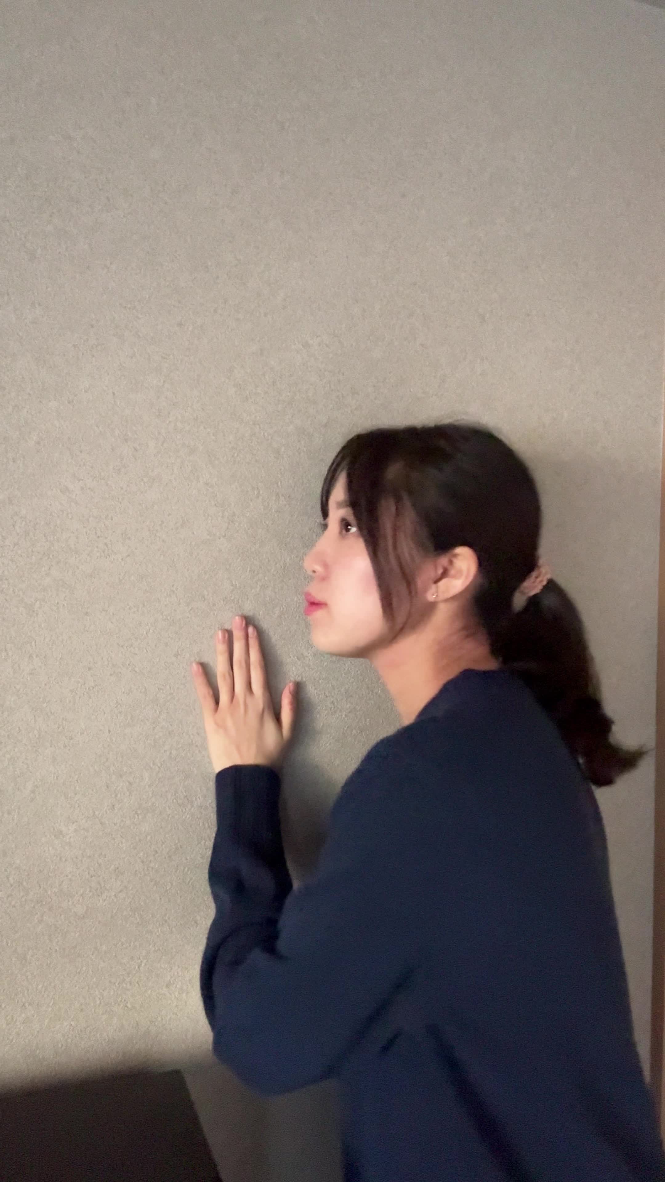 壁に耳を当てて何かを聞いているような仕草