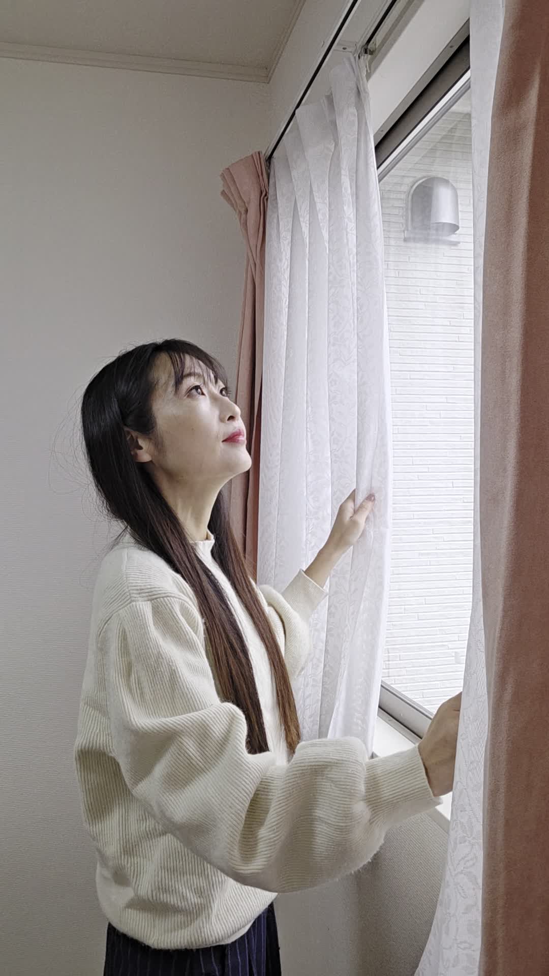 窓際に立って、カーテンを動かす仕草