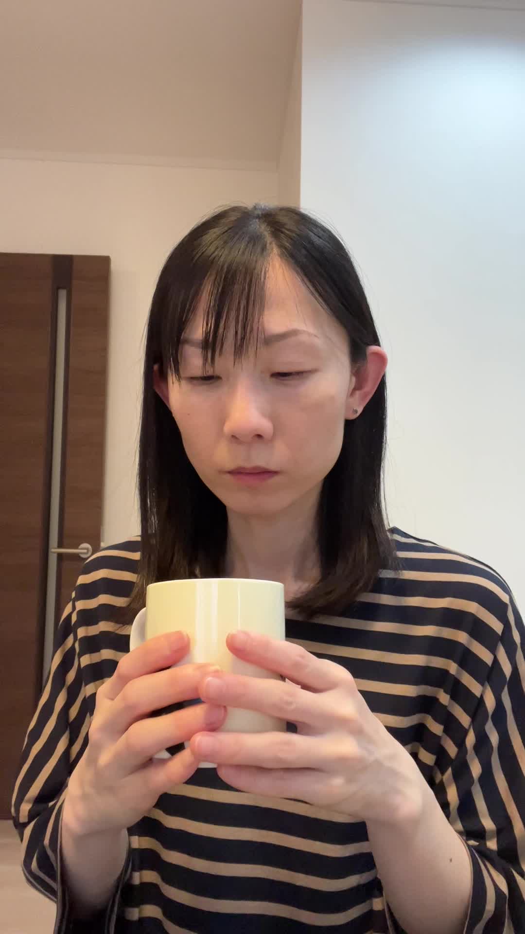 椅子に浅く腰掛け、「飲み物で少しでも元気を取り戻せる？」と悩む様子