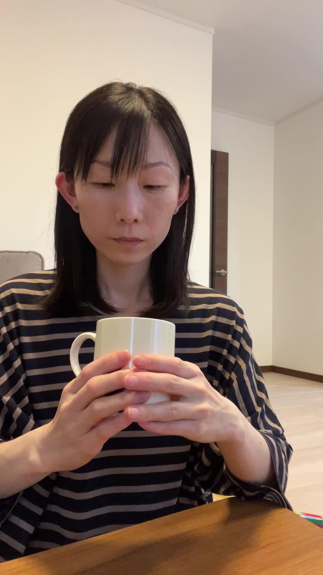テーブルで飲み物を手に取り、「これで改善するなら試したい」と期待する微笑み