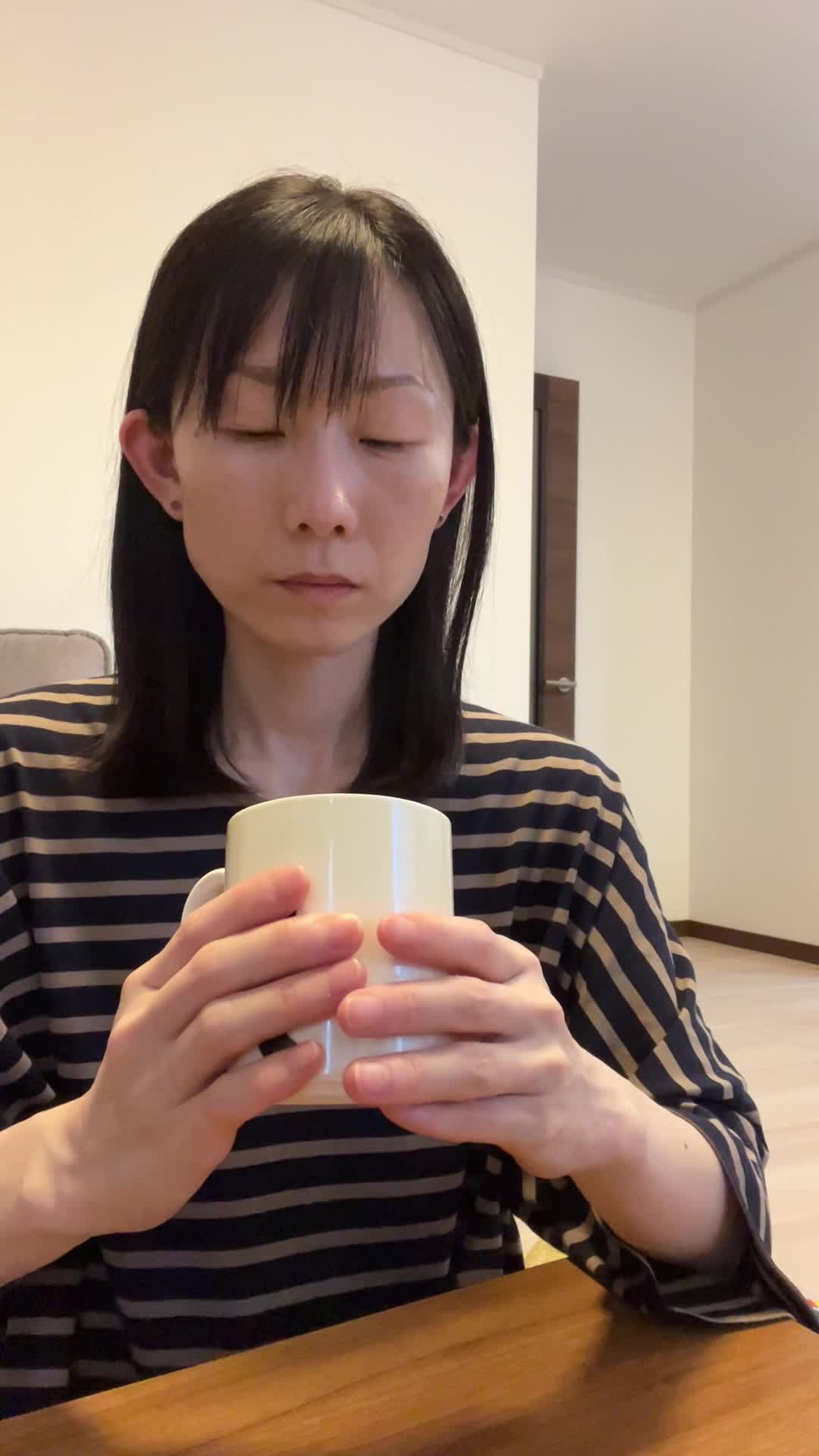 テーブルでカップを手に取り、「少しずつ体が良くなる期待を込めて飲み始める」微笑み