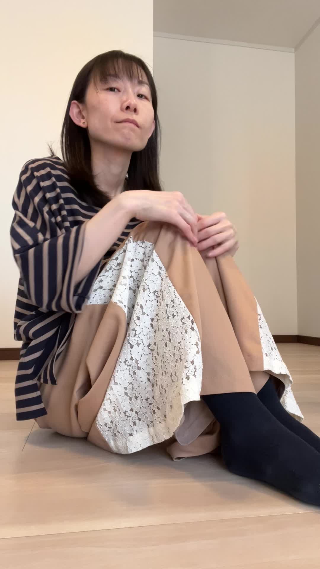 床に座り込み、「最近体が重くて動きが鈍い」と両手を膝に置いて考え込む姿