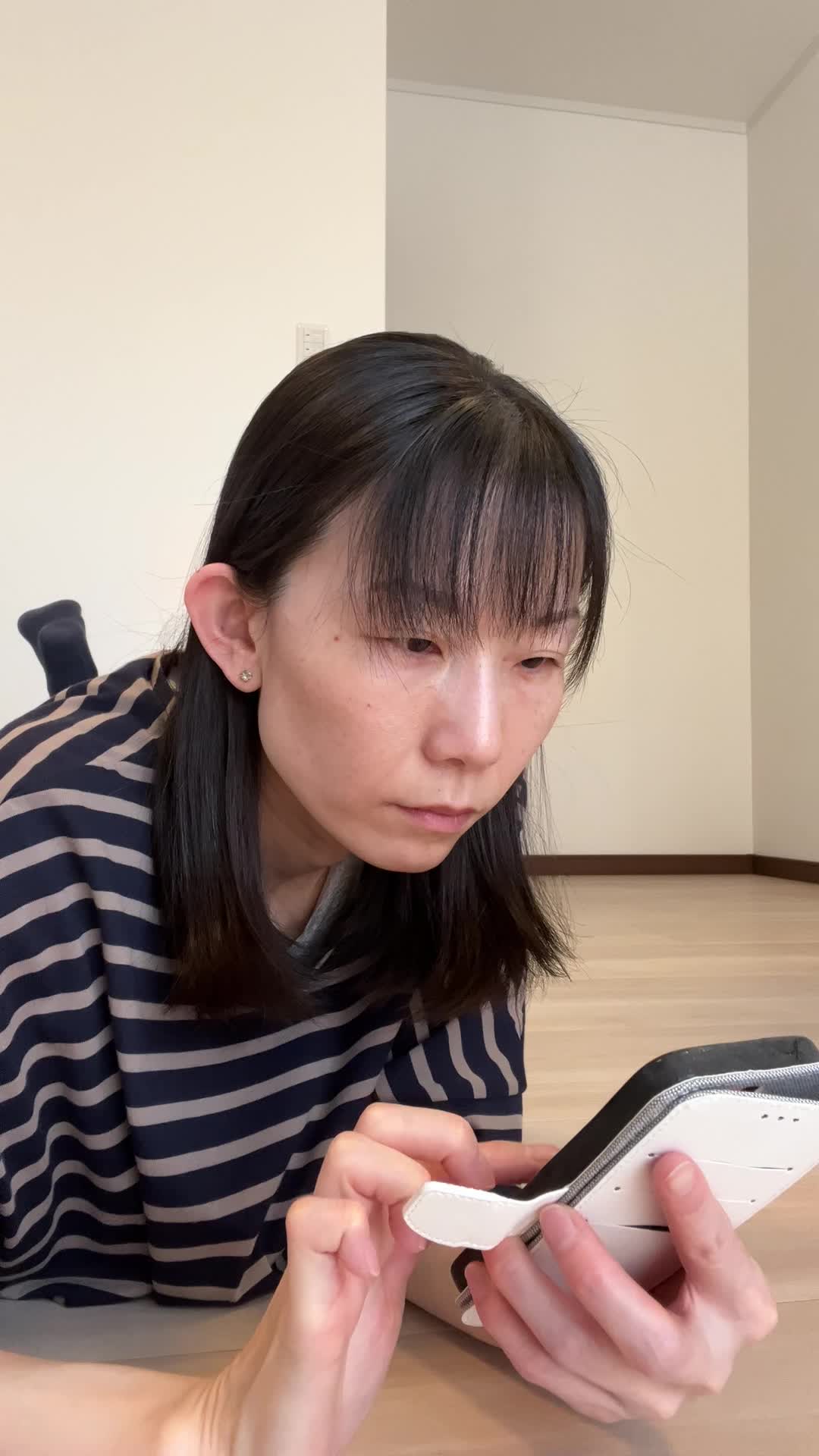 床でスマホを操作しながら、「健康ドリンクが自分に合うか調べている」真剣な姿