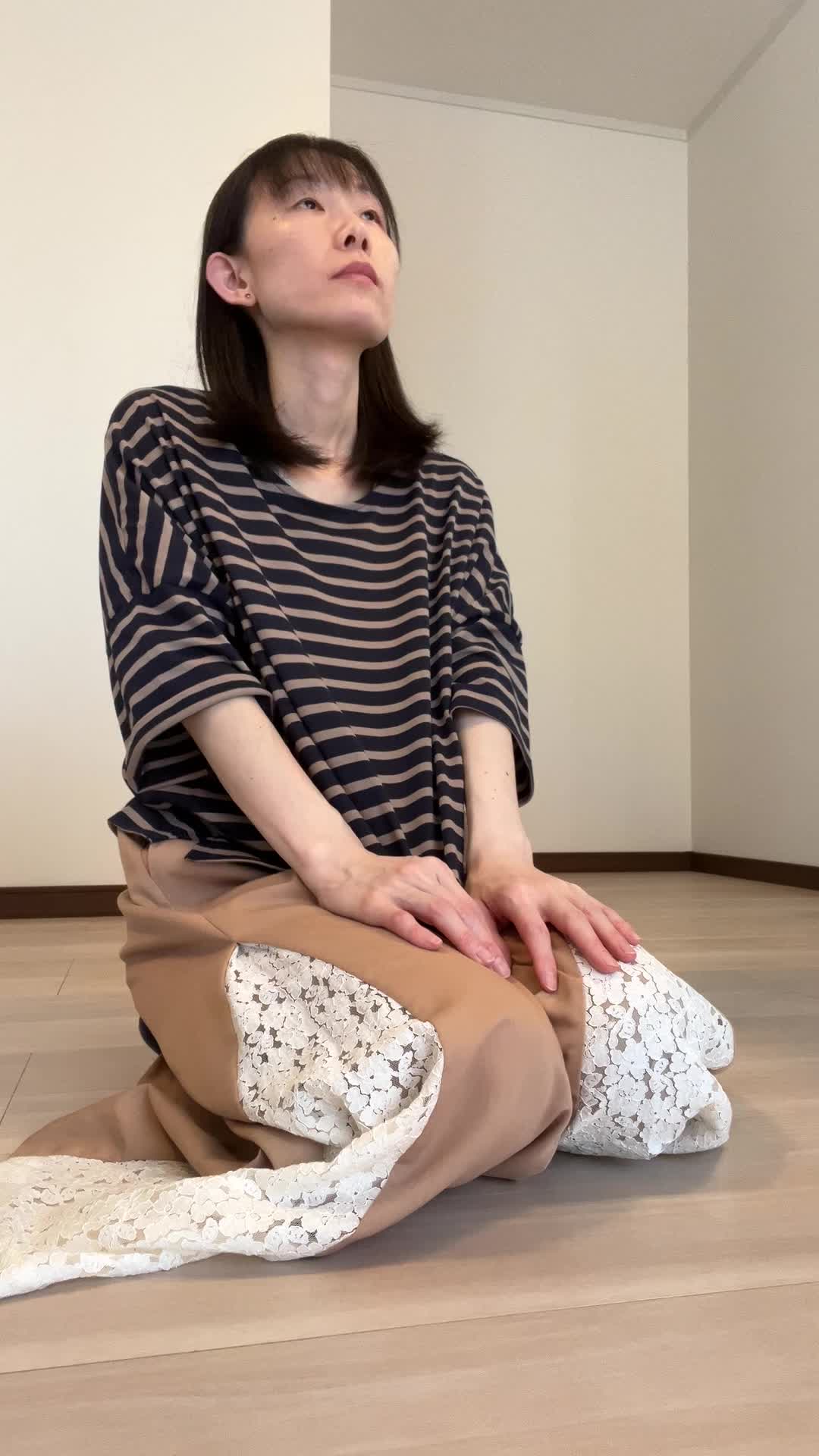 床で両手を膝に置き、「健康ドリンクで元気を取り戻したい」と決意を固める姿