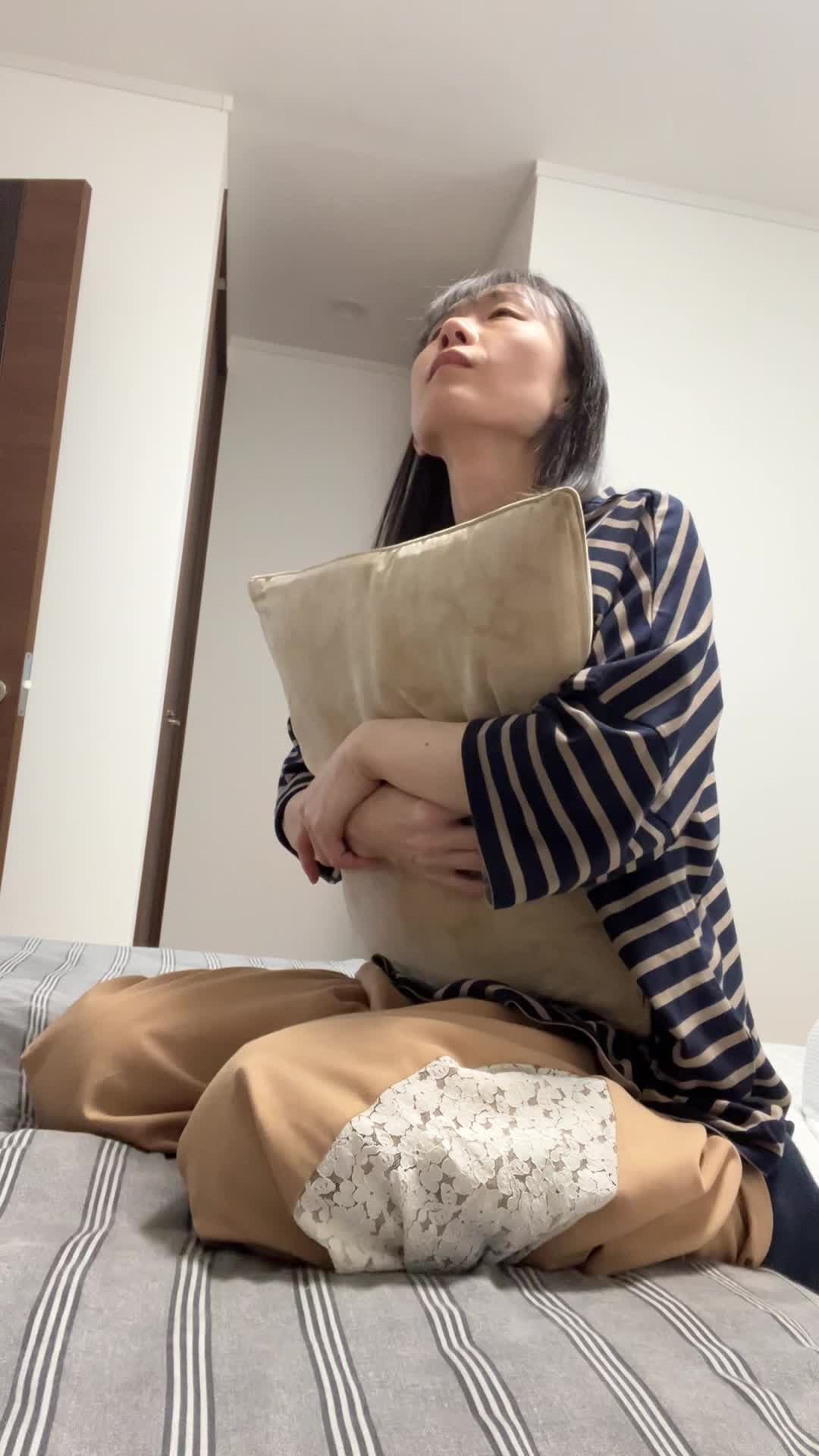 ベッドでクッションを抱え、「このドリンクを続けたら変化があるかな？」と未来を想像する表情