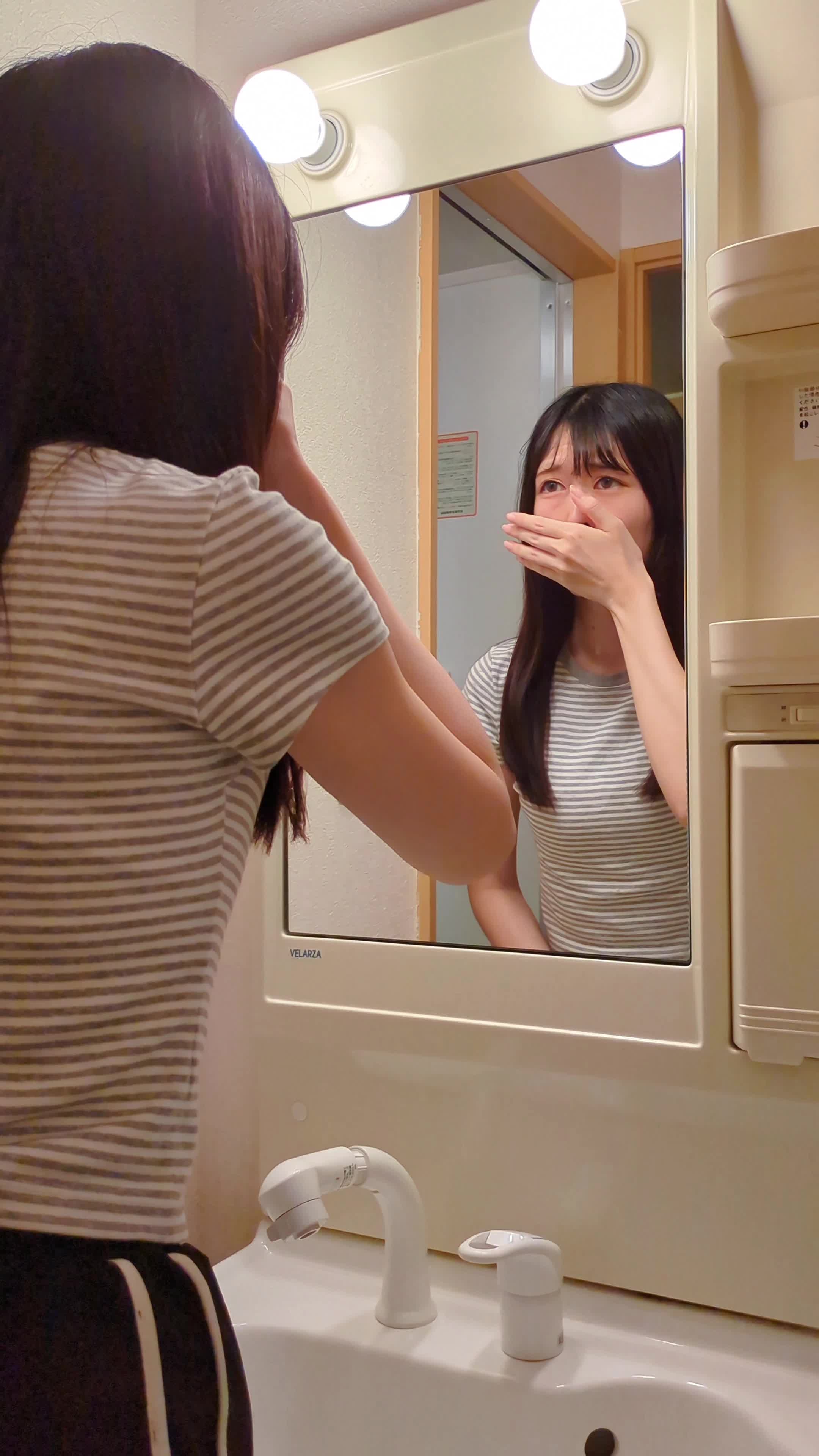鏡の前で口元を手で隠しながら「どうしよう…」と困った表情をする