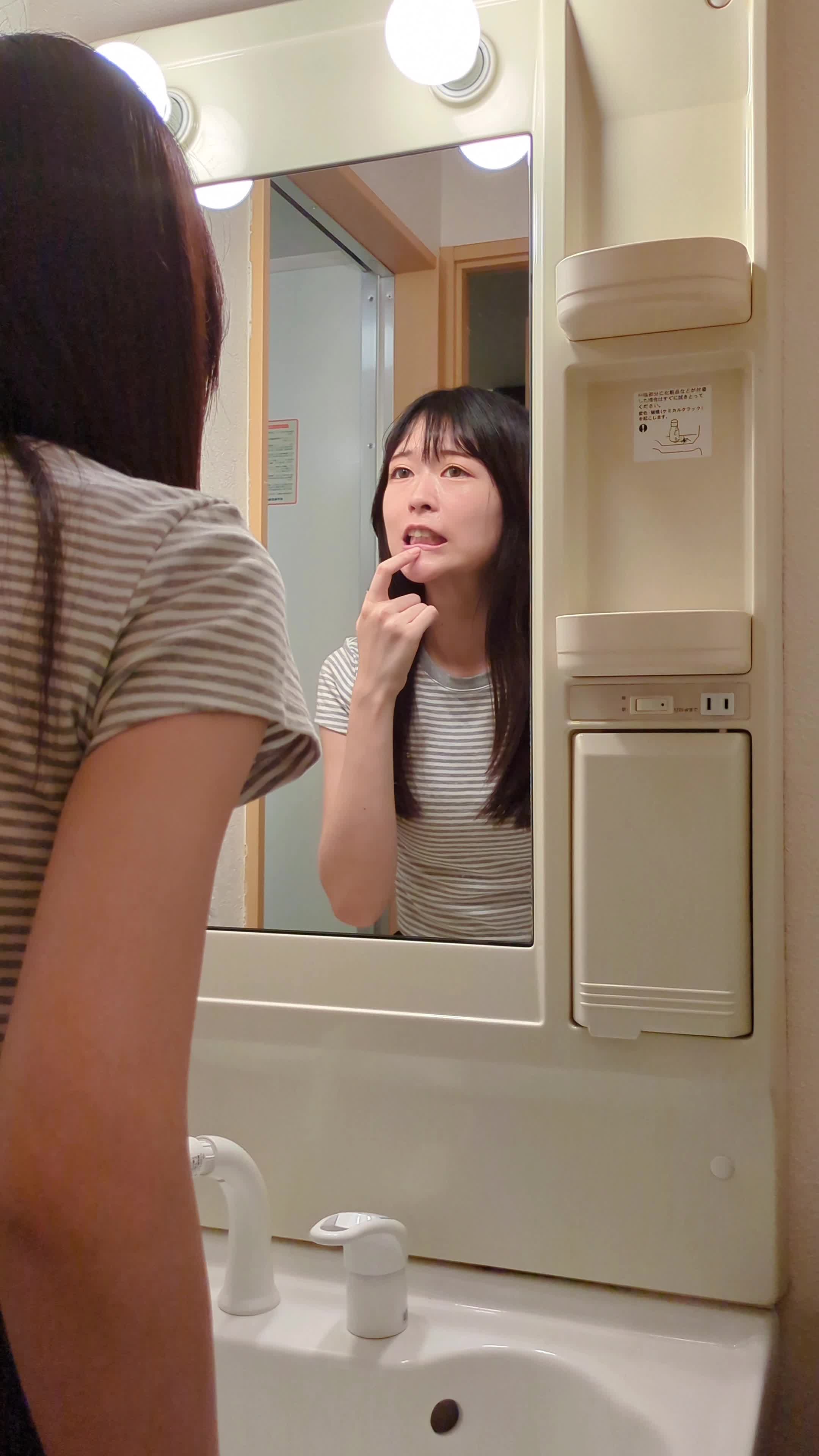 鏡越しに「輝きが足りないかも…？」と眉をひそめて考える動作