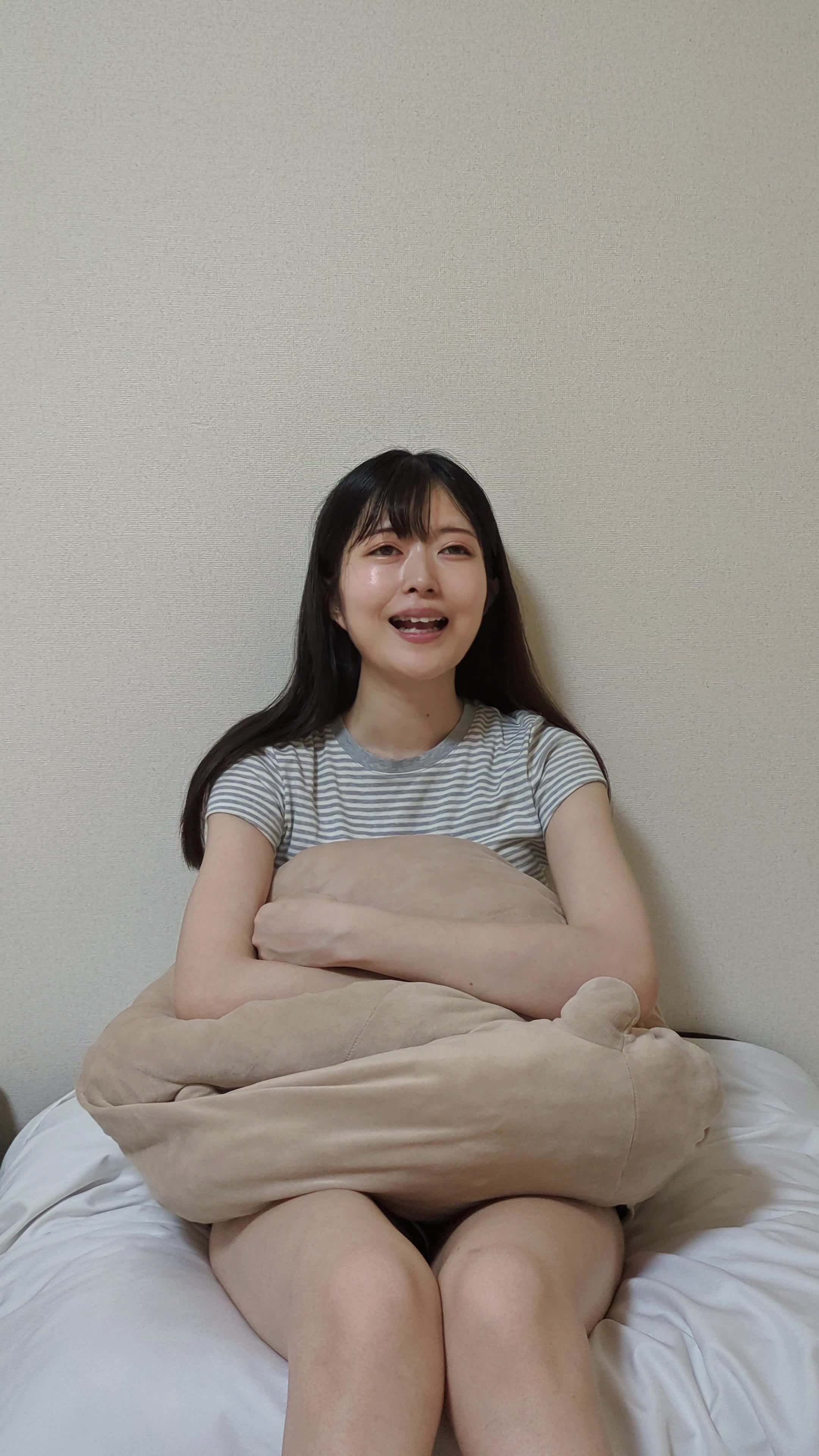 ソファに深く座り、笑顔の練習をしながら「まだまだ…」と首を傾ける仕草
