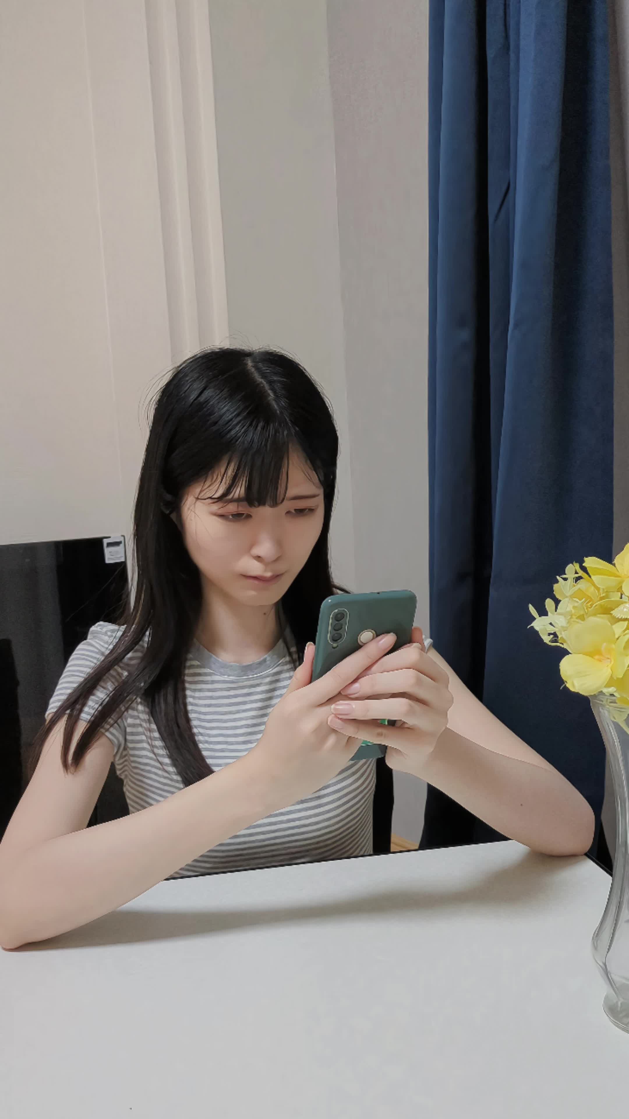 テーブルに肘をついて、笑顔の写真をじっと見つめる真剣な表情