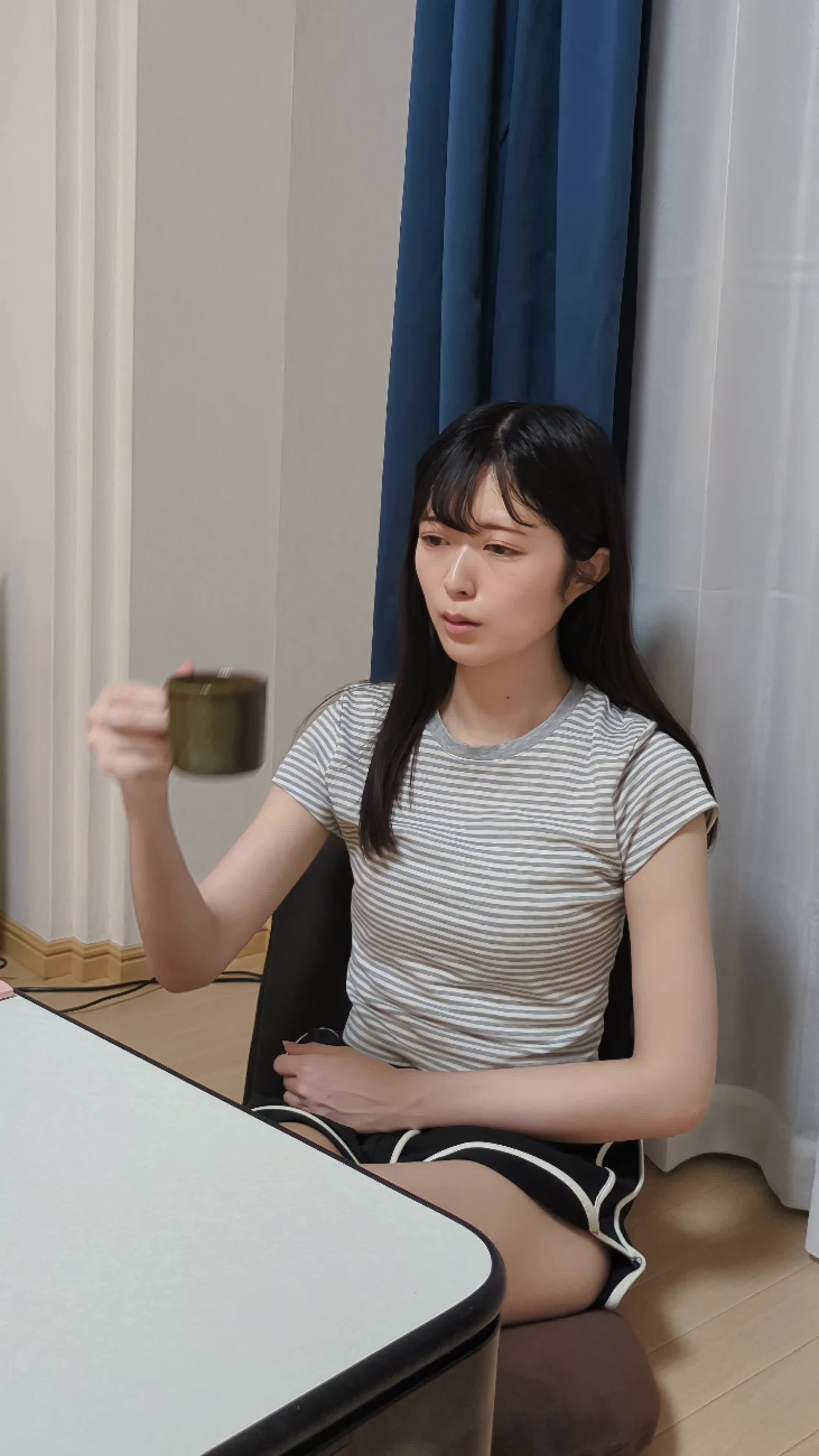 カップを持ち、「コーヒーが歯に悪いって本当かな？」と考える動作