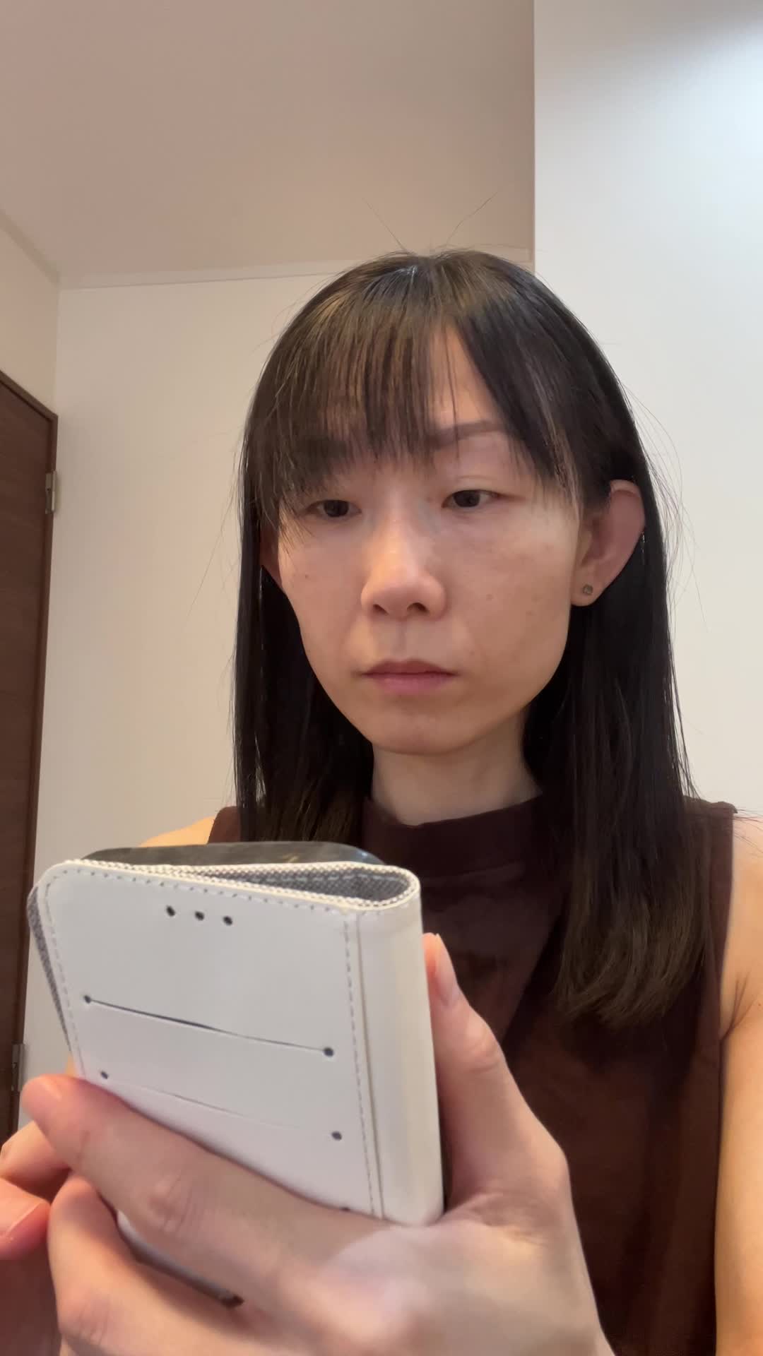 スマホを見て首をかしげ、「ちょっと怪しい？」と眉を上げる動作