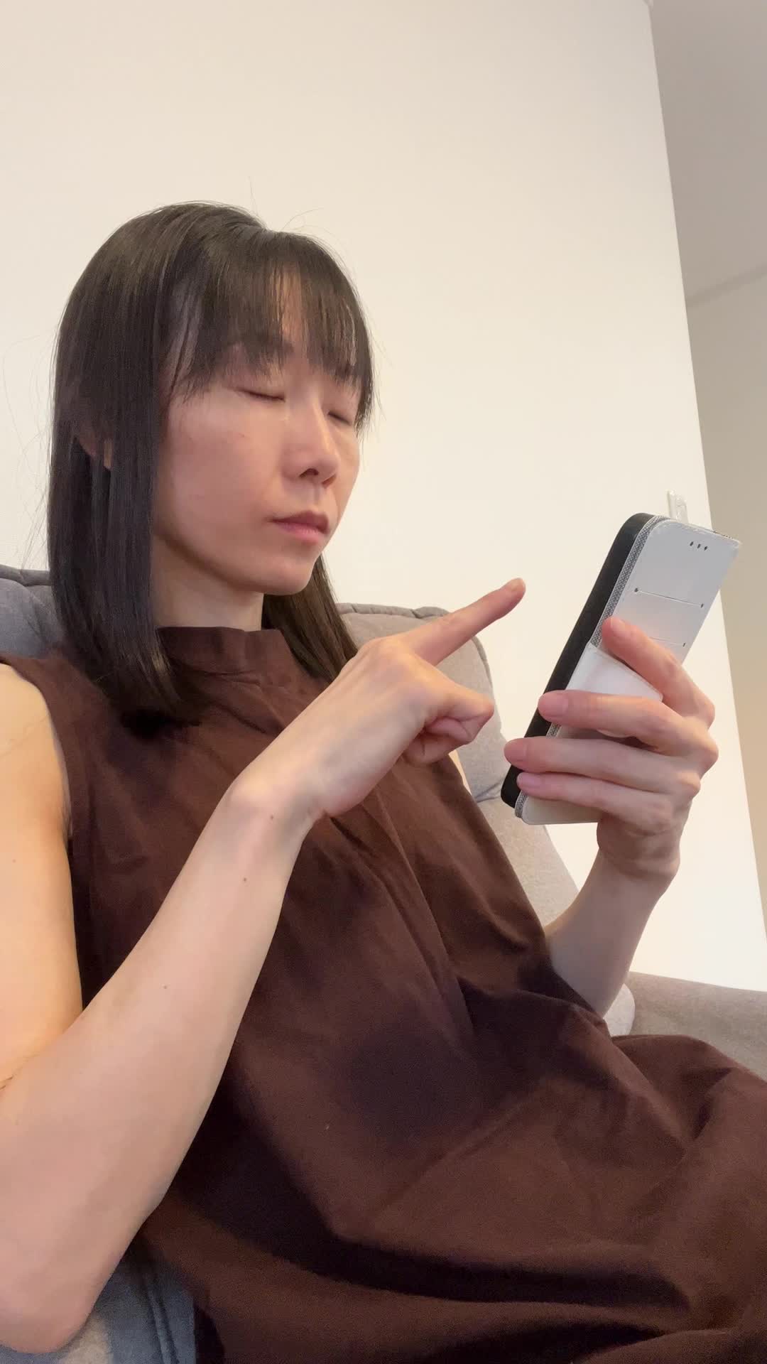 ソファでスマホを指差し、「ほら、これ！」と確信に満ちた笑顔