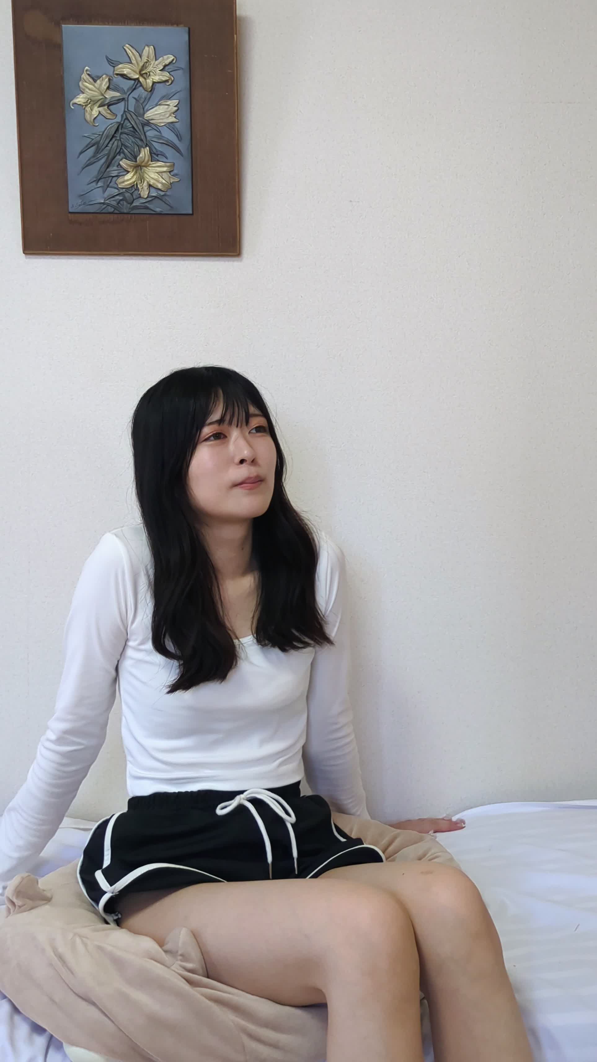 ソファで足を組み直しながら、リラックスした表情を見せる