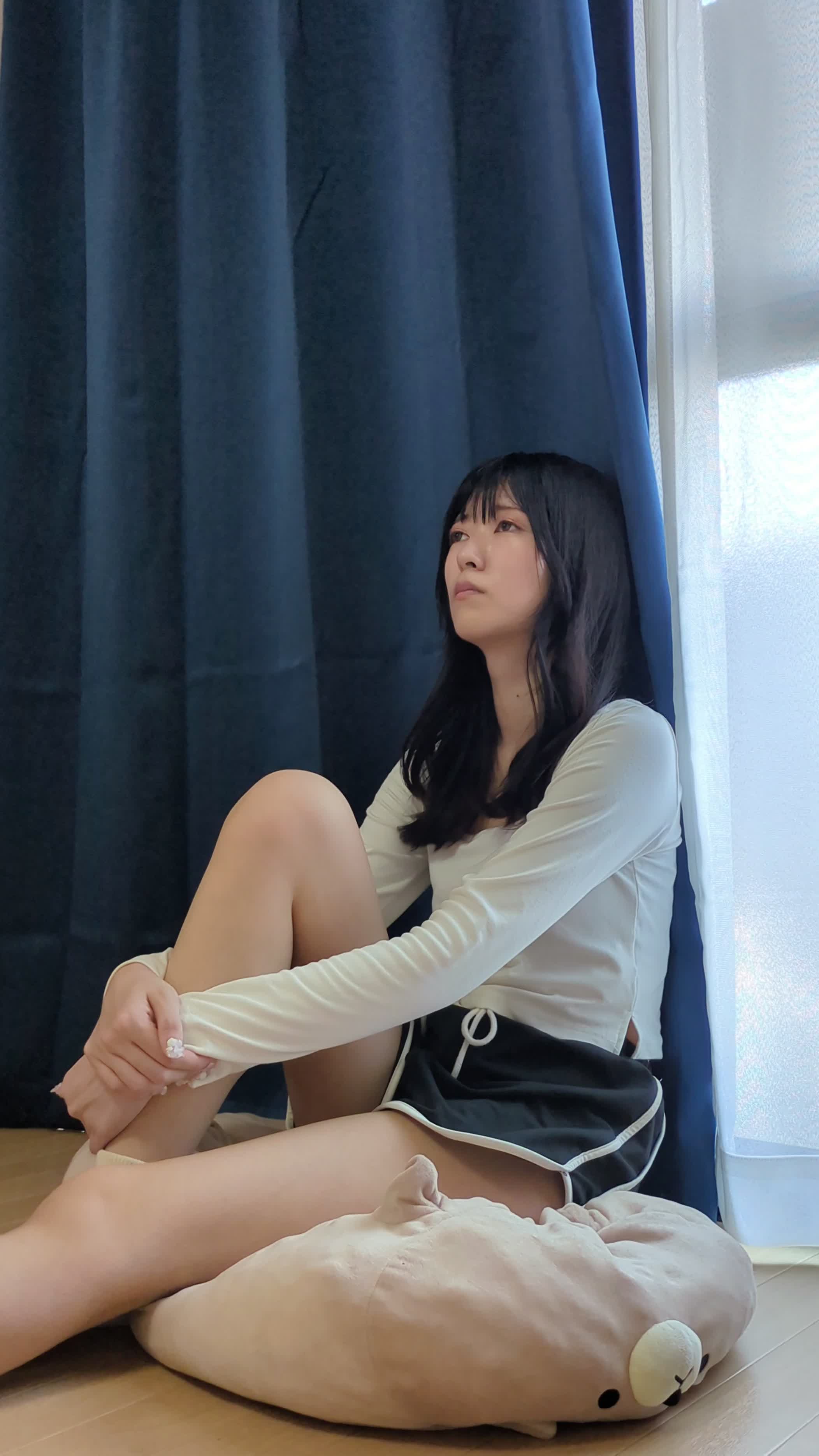 床に腰掛け、片膝を立てて体を支えながら物思いにふける
