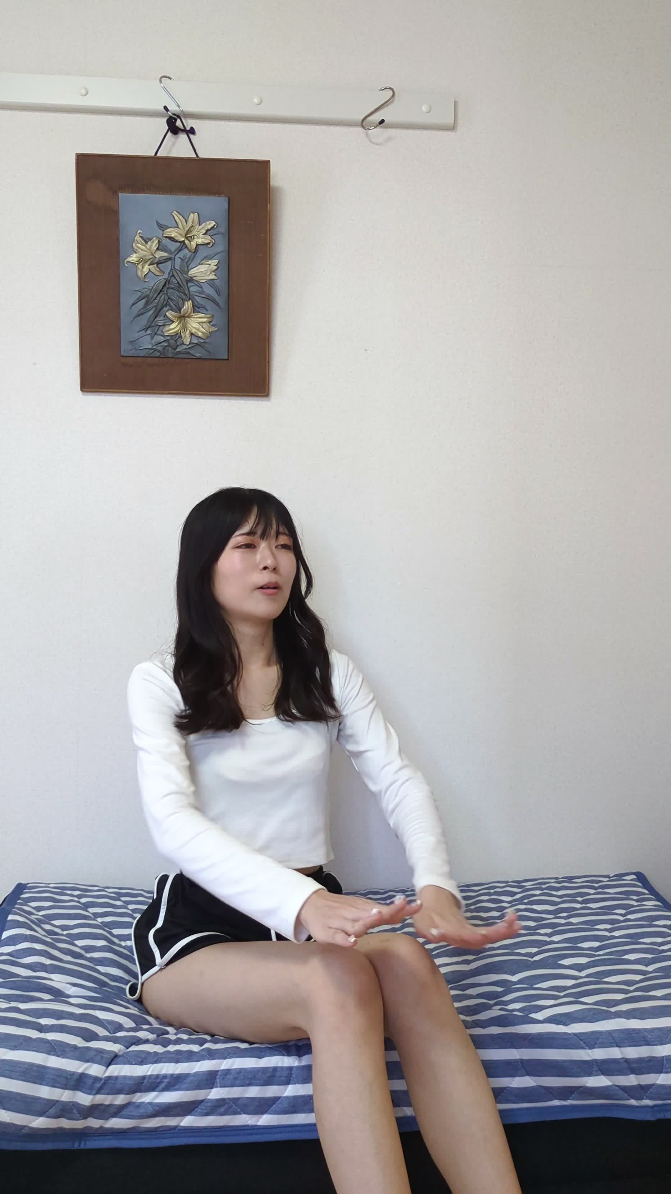 椅子に座りながら体を前に倒し、背中を軽く伸ばしている