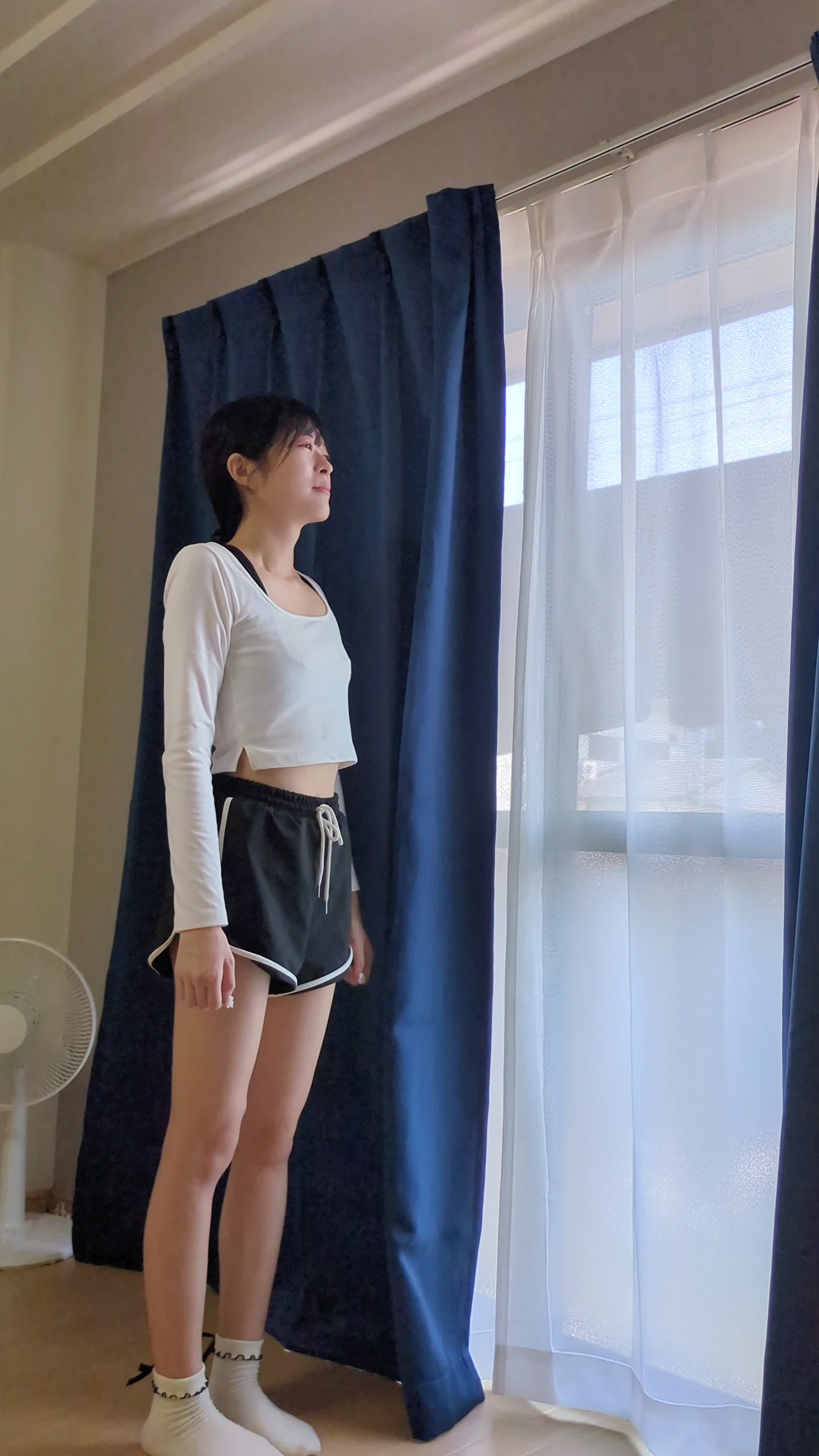 窓際で外を眺めながら肩を軽く上下に動かしてリフレッシュする