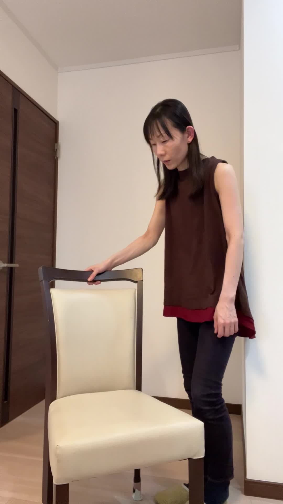 椅子を持ち上げようとして「思ったより重い…！」と驚く表情