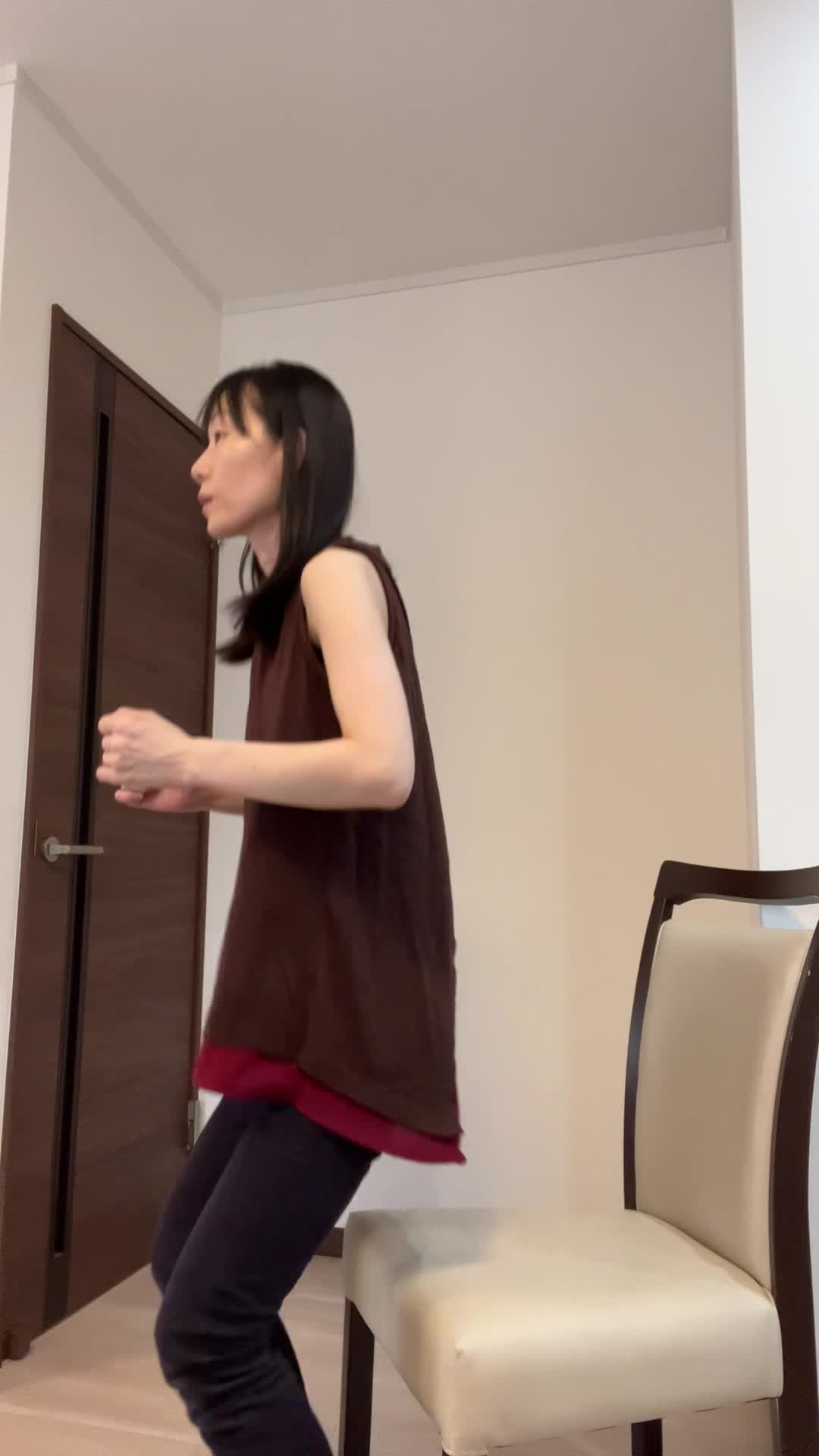 椅子を使ってスクワットをするが、途中でバランスを崩すコミカルな動作