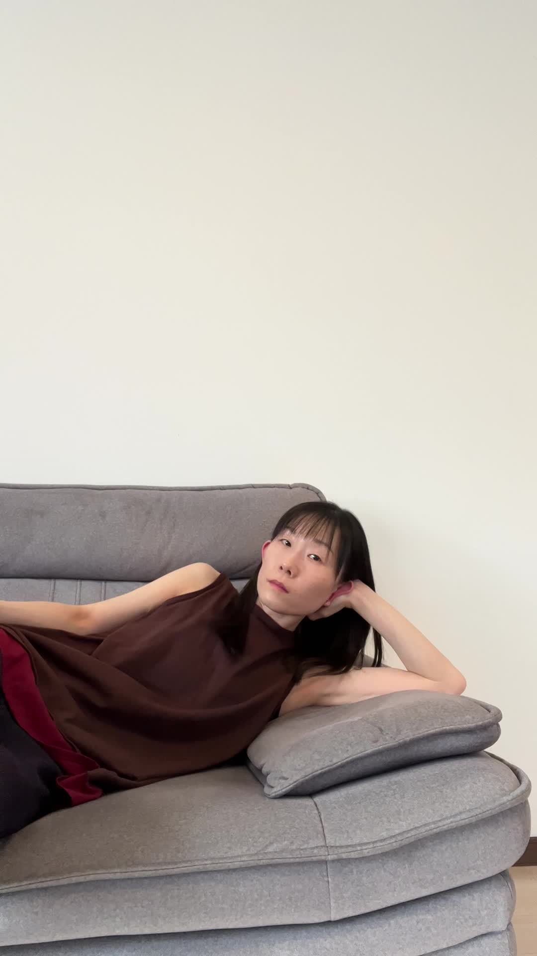 ソファで横になりながら、筋トレ動画を見て「これ無理だろ！」と驚く表情