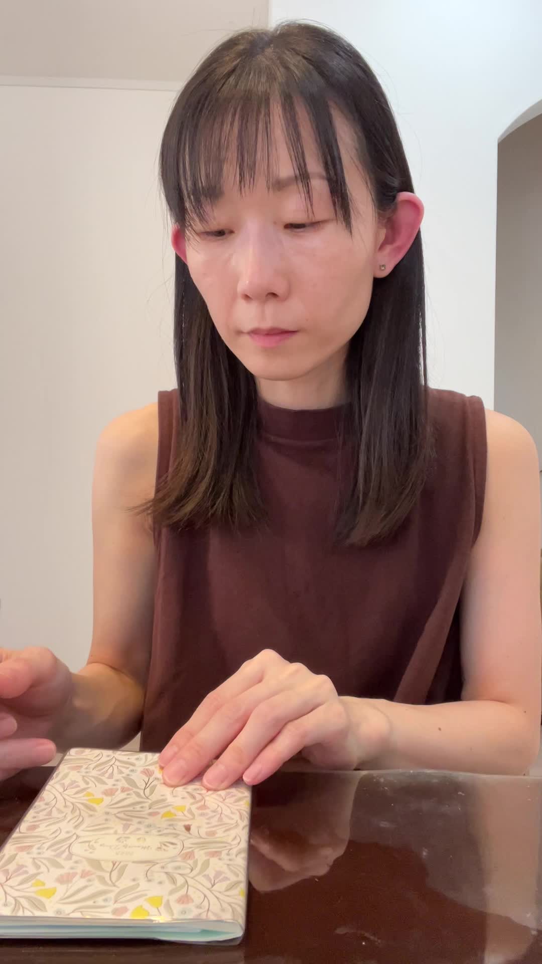 テーブルで手帳を開き、エクササイズのスケジュールを書き込みながら頷く姿