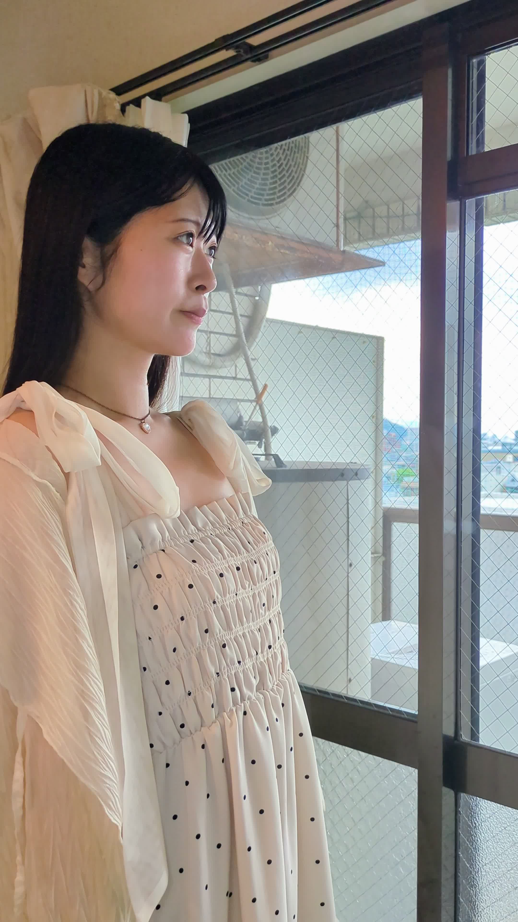 窓の外を眺めながら顔を手で撫でつけてリフレッシュする仕草をする