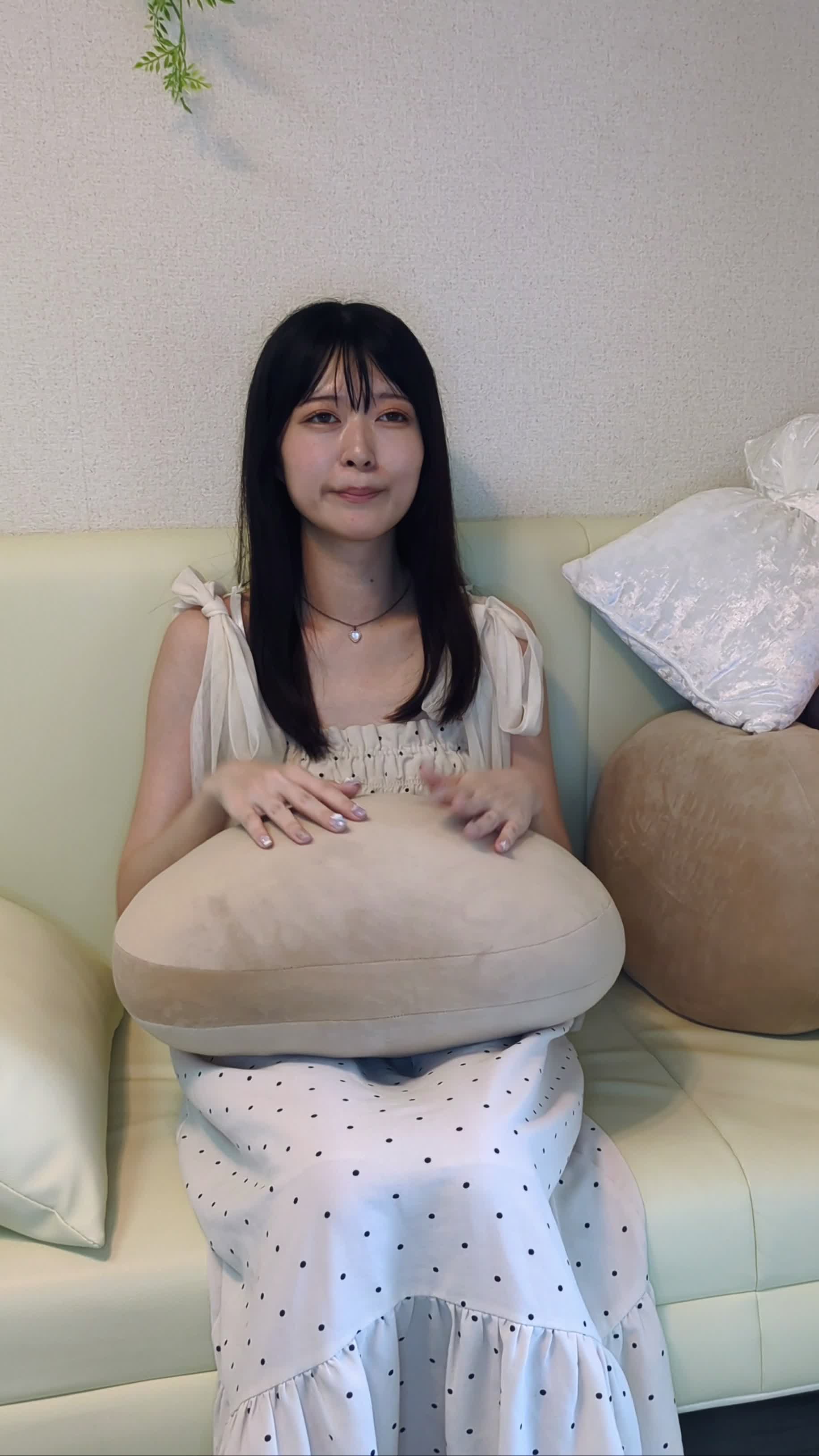 ソファに腰掛け、リラックスしながら両手を頬に当てる仕草をする