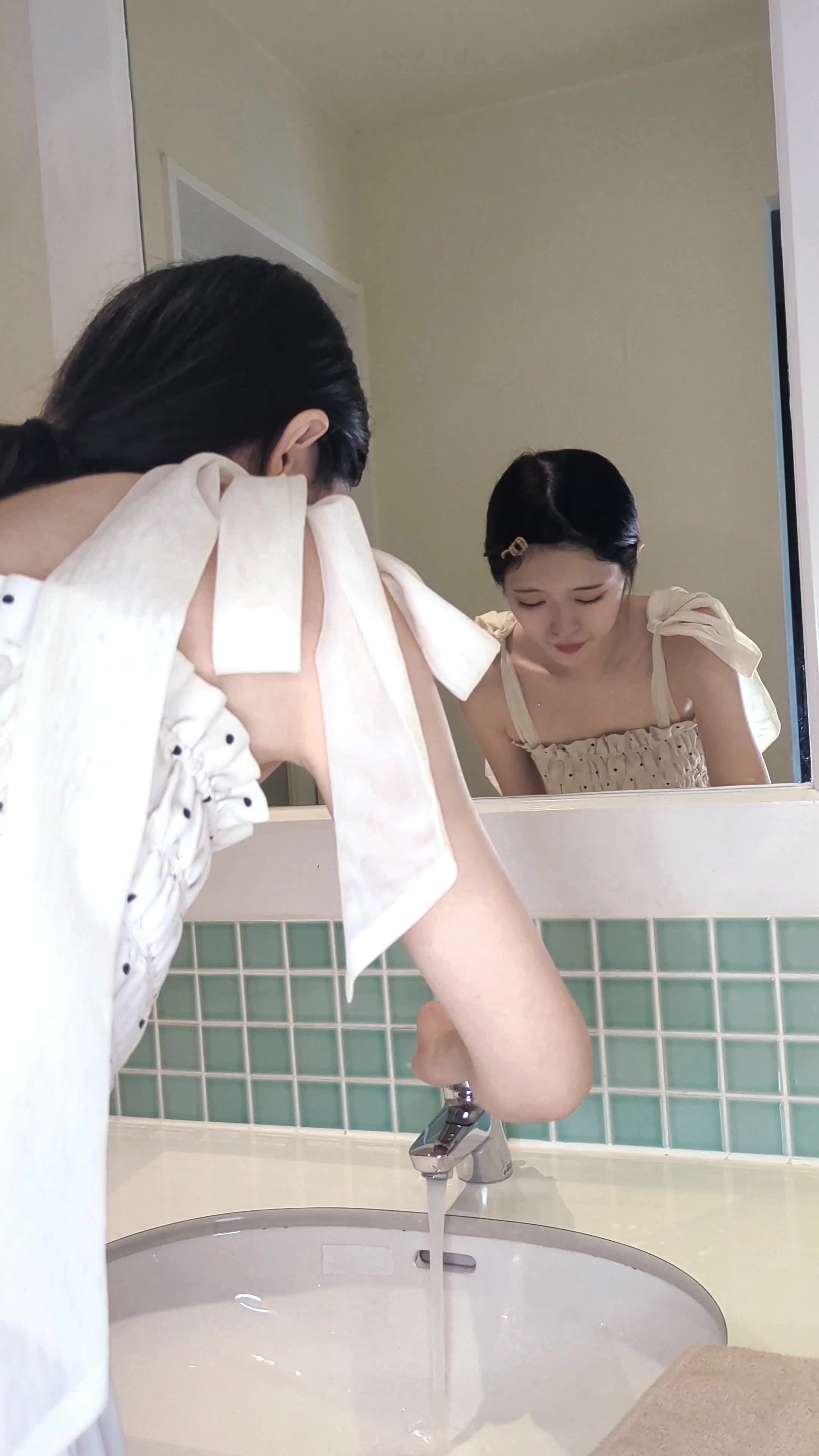 洗面台で顔を軽く水で洗った後、タオルで拭き取る仕草を見せる