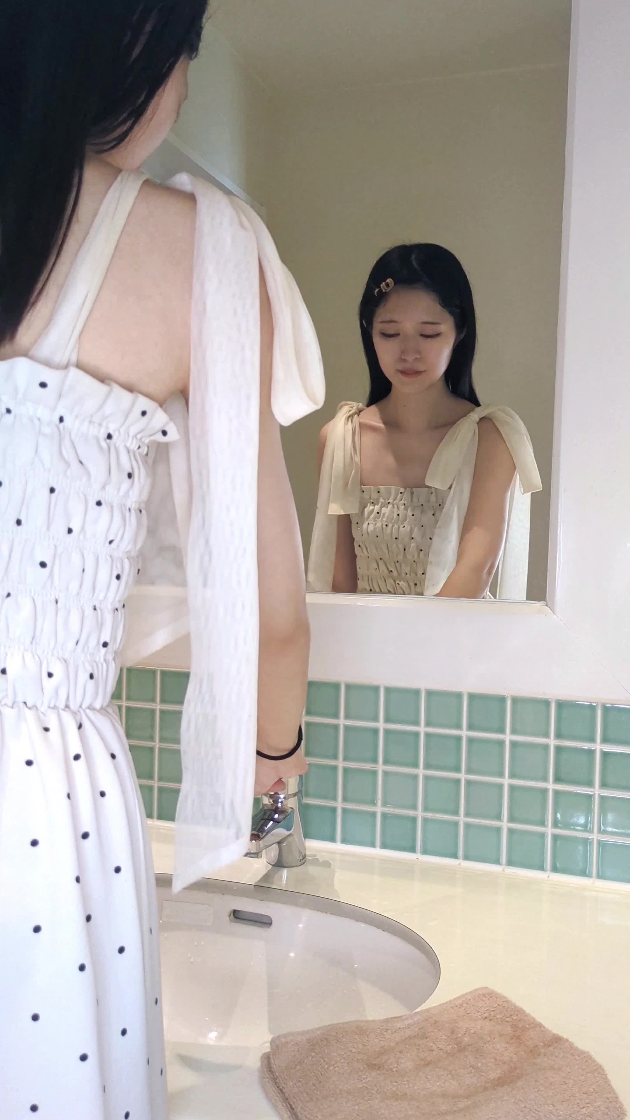 洗面台で手を洗い、顔を軽く拭いている様子を見せる