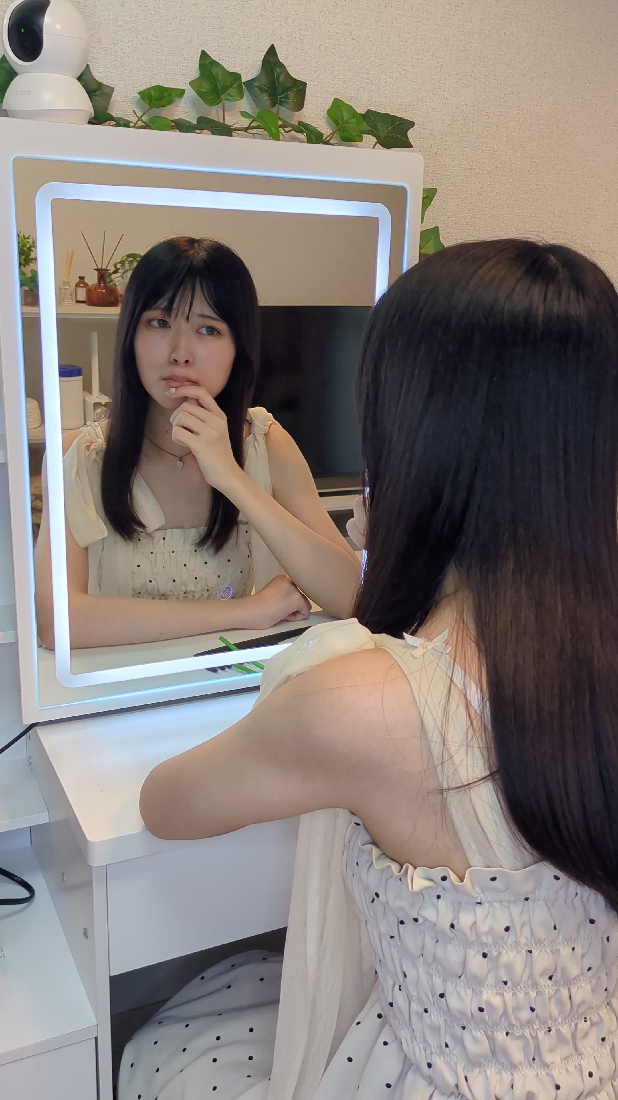 指先で唇を軽く触りながら肌の状態を気にしている仕草をする