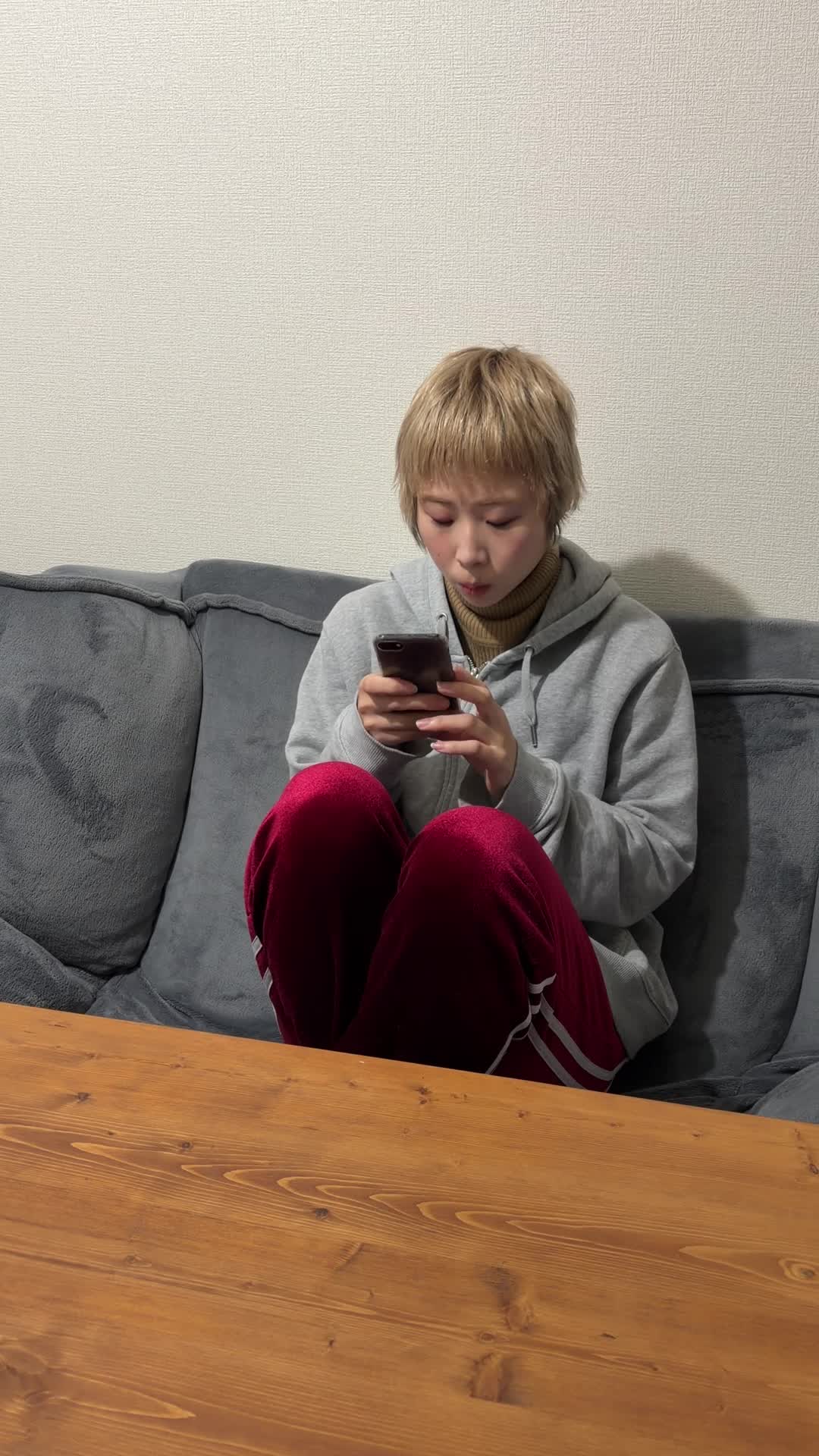 椅子に腰掛け、スマホで査定フォームを入力しながら期待する顔