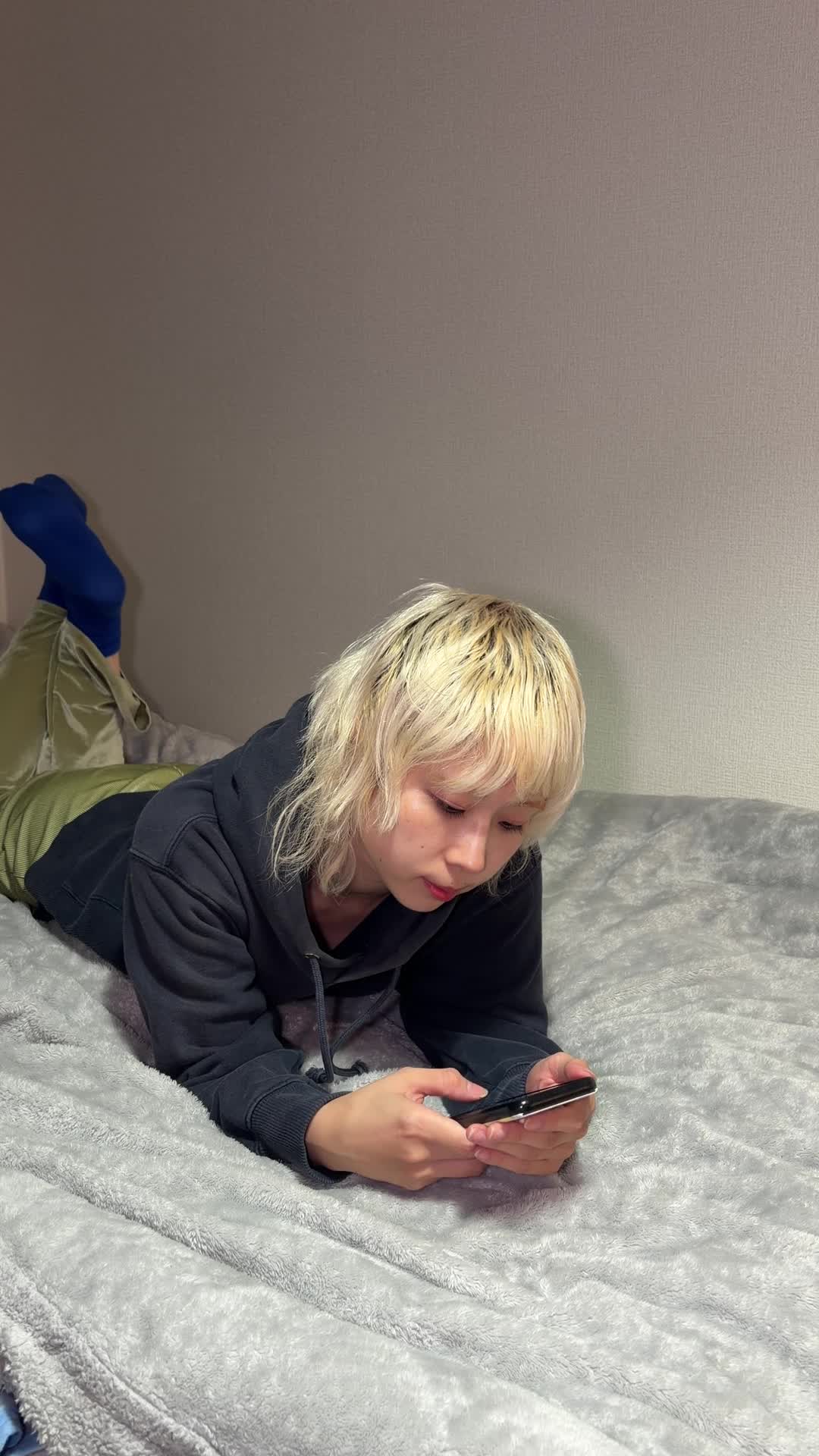 ベッドで横になり、スマホで転職サイトを閲覧している
